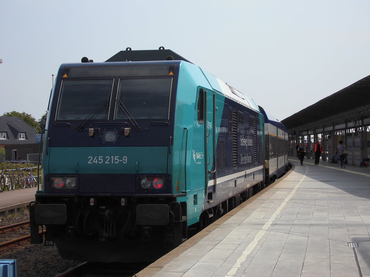 BR 245 der DB (Nah SH) steht mit Married-Pair-Wagen steht als RE 6 nach Hamburg Altona im Bahnhof Westerland (Sylt).

Juli 2017