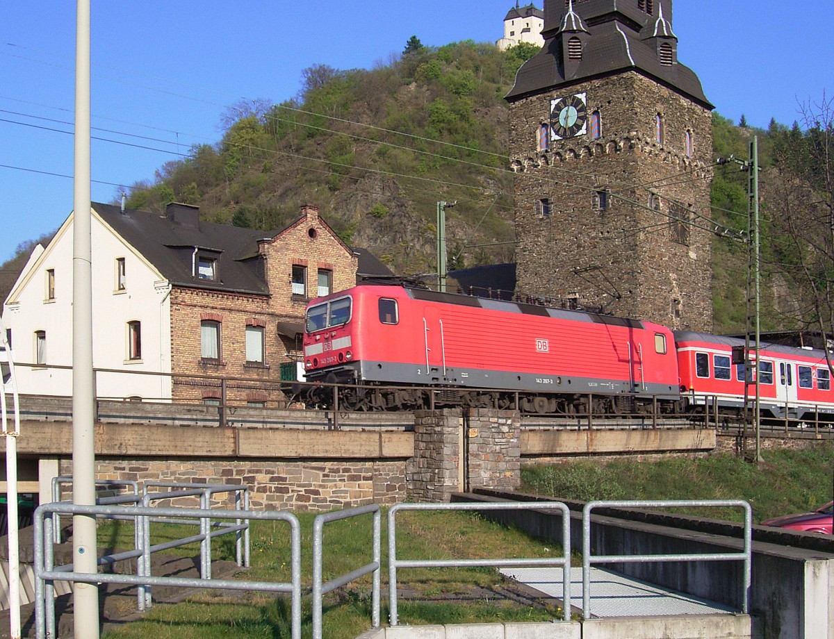 Braubach/Rhein: Am 11. April 2007 folgt 143-267-3 dem Güterzug mit einem Nahverkehrszug ebenfalls stromabwärts Höhe südlicher Bahnhofseinfahrt. Im Hintergund die Marksburg und ein Stadturm.