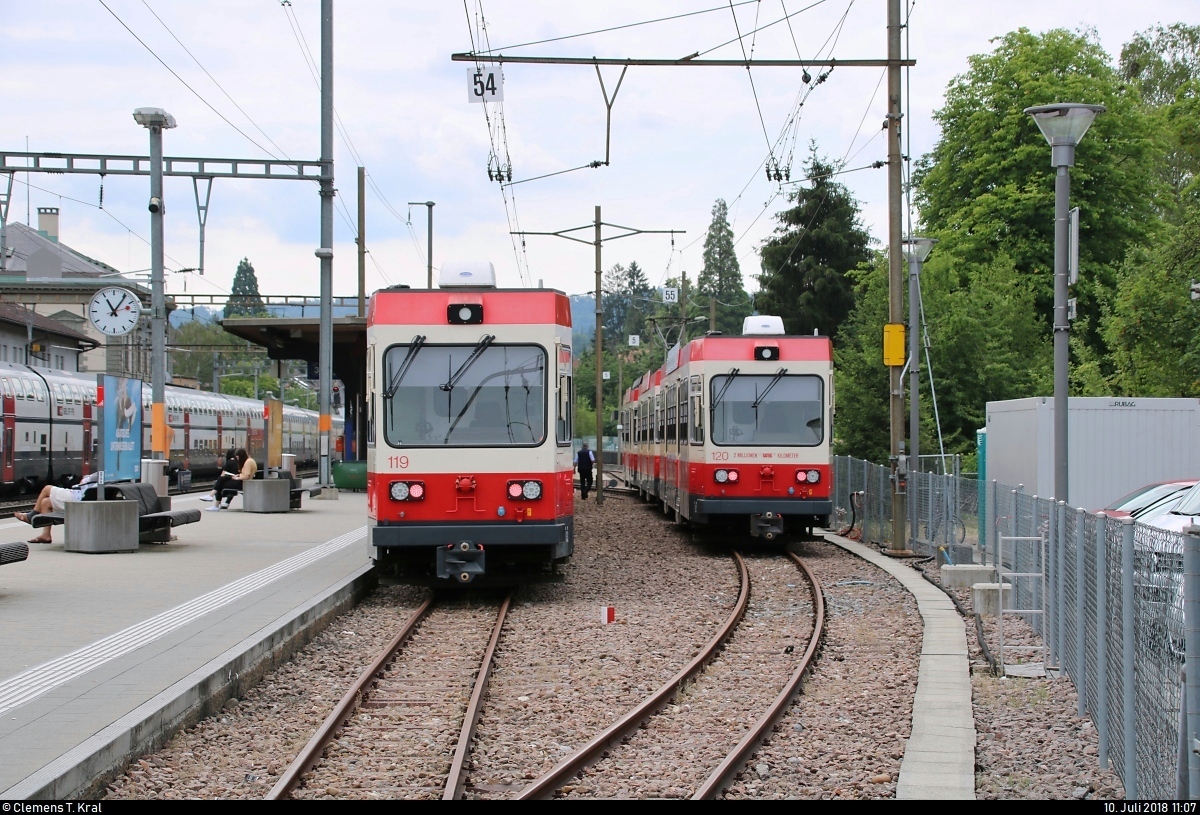 Bt 119 und Bt 120 der Waldenburgerbahn stehen im Bahnhof Liestal (CH).
Aufgenommen vom offenen Bahnübergang für Fußgänger zwischen Parkplatz und Bahnsteig.
[10.7.2018 | 11:07 Uhr]