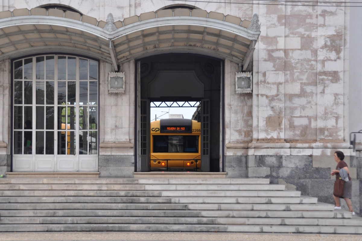 COIMBRA (Distrikt Coimbra), 24.09.2013, Blick auf das Eingangsportal des Bahnhofs Coimbra-A, des in der Stadt gelegenen, eigentlichen Hauptbahnhofs, der heute aber nur noch dem Regionalverkehr dient; im Hintergrund zu sehen ist Wagen 2266 der Baureihe 2200 als Regionalzug nach Figueira da Foz