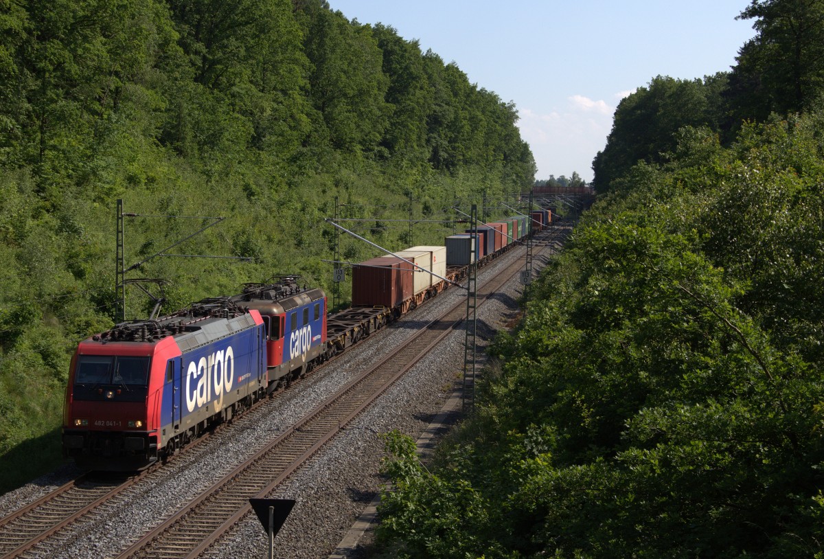 Containerzug auf dem Weg von Hof nach Hamburg im Waldeinschnitt bei Jößnitz. Es zieht die 482 041-1 und kalt dahinter die  Heidi  421 381 am 12.06.2015.
