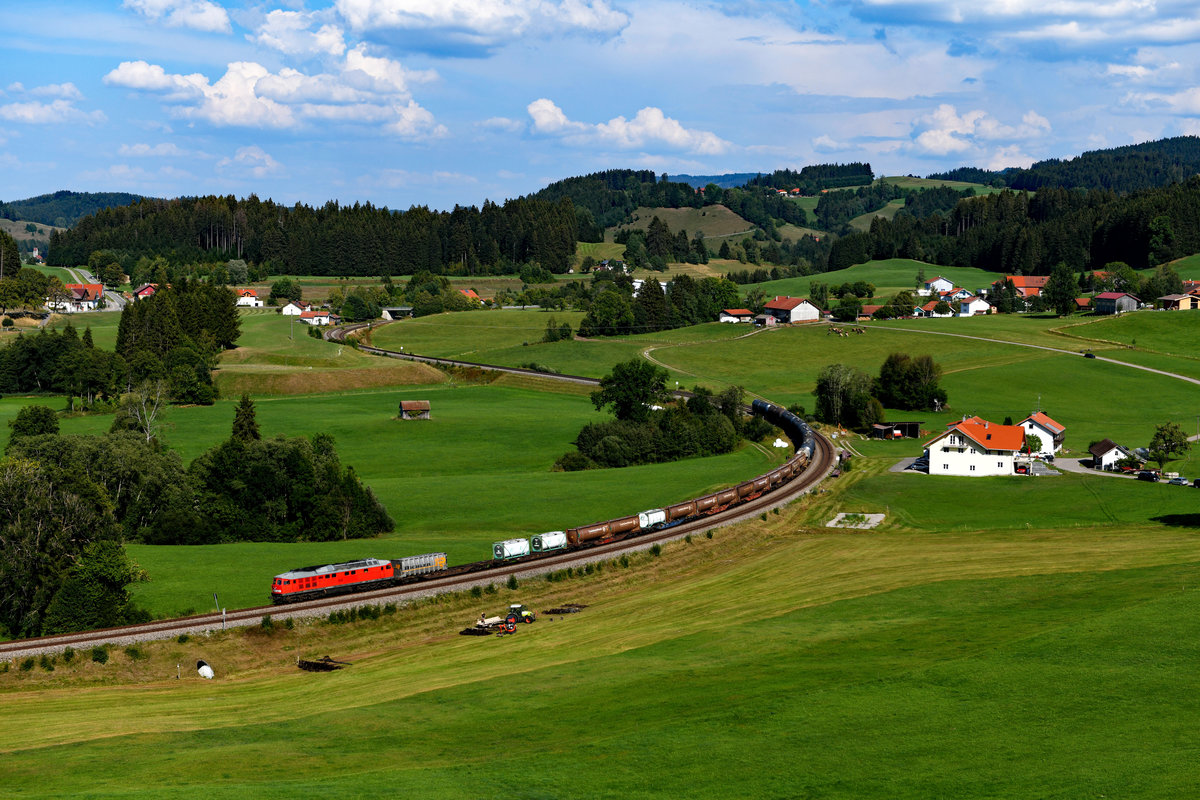 Das letzte Foto des Tages bei Harbatshofen wurde dann regelrecht zum  Wimmelbild , so viel gibt es darauf zu entdecken. Hauptdarsteller war natürlich 232 609 mit dem umgeleiteten EZ 45194 von Hall in Tirol nach Bludenz. Links kann man im Bildhintergrund noch die Kirche von Erbatshofen erkennen. Im Vordergrund war der Bauer mit Arbeiten auf dem Feld beschäftigt. In den Bergen braute sich inzwischen ein Gewitter zusammen - Zeit also, den Heimweg nach einem überaus erfolgreichen Ausflug ins Allgäu anzutreten. 