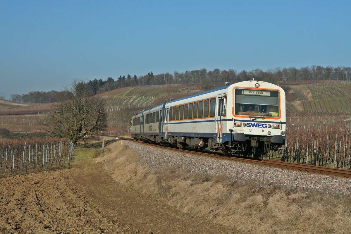 Das NE81-Dreigespann auf der Kaiserstuhlbahn bestand am 15.02.17 aus dem altlackierten Steuerwagen 926 204-8 und den beiden Triebwagen 626 129-0 und 626 128-2. Die hübsche Garnitur ist hier auf dem Weg von Riegel DB nach Breisach bei Burkheim zu sehen.