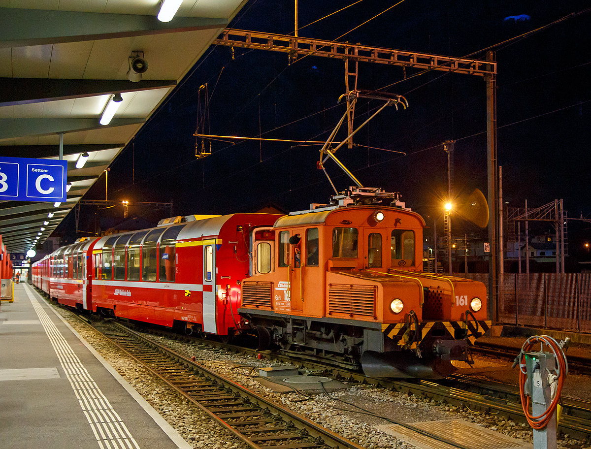 
Das RhB  Eselchen  161 bzw. der Rangiertraktor RhB Ge 2/2 161, ex BB Ge 2/2 61 rangiert am 18.02.2017 einige Wagen im RHB-Bahnhof Tirano. 

Der RHB-Bahnhof Tirano ist der Endbahnhof der Berninabahn und bedingt dadurch ein Kopfbahnhof. Bei den meist von Triebwagen geführten Züge werden dann die Personenwagen (teilweise auch Güterwagen) abgehangen und von der RhB Ge 2/2 auf ein anderes Gleis rangiert. Danach setzt der Triebwagen um und setzt sich für die Gegenrichtung wieder vor die Wagen.

Von der kleinen Elektrolokomotive Ge 2/2 wurden nur zwei Loks von diesem Typ für Berninabahn (BB) , heute der Rhätischen Bahn (RhB), gebaut, ursprünglich die BB 61 und BB 62, seit 1961 mit den Nummern RhB 161 und 162.

Beide Gleichstromloks wurden 1911 von der Berninabahn (BB) für Vorspanndienste beschafft, sie wurden von SIG und Alioth gebaut. Die damals noch braun lackierten Maschinen erhielten die Nummern Ge 2/2 61 und 62 und waren noch mit Lyra-Stromabnehmern bestückt. Nach der Übernahme der BB durch die RhB im Jahre 1942 wurden sie verschiedentlich modernisiert; sie tragen heute einen Einholmstromabnehmer und sind meistens als Rangierloks in Tirano und Poschiavo tätig.

Sie werden wegen ihrer Form auch  Mini-Krokodile  oder wegen ihres Aufgabenbereichs  Eselchen  genannt.  Zwischen den Vorbauten ist ein Gang, so dass ein Übergang zum Zug möglich war. Die Benutzung ungeschützter Übergänge ist aber inzwischen selbst dem Personal untersagt, so wurden folgerichtig an den beiden Loks die Übergangsbleche entfernt. Die Loks sind die zweitältesten im Dienst befindlichen Lok der RHB.

Technische Daten der Ge 2/2
Betriebsnummern: 161 und 162 (ex 61 und 62)
Hersteller: SIG, Alioth
Baujahr: 1911
Anzahl Fahrzeuge: 2
Spurweite: 1.000 mm
Achsanordnung: B
Länge über Puffer: 7.740 mm
Breite: 2.500 mm
Achsabstand: 
Triebraddurchmesser (neu): 975 mm
Dienstgewicht:  18.0 t
Höchstgeschwindigkeit: 45 km/h
Stundenleistung: 250 kW (340 PS)
Anfahrzugkraft: 37,6 kN
Stundenzugkraft: 27,5 kN bei 27 km/h
Motorentyp:  Gleichstrom Reihenschluss
Fahrleitungsspannung: 1 kV DC (Gleichstrom) / 750 V DC vor 1935 