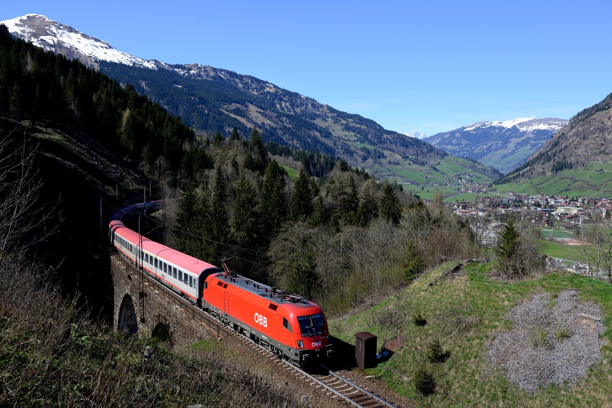 Das Schlossbach-Viadukt zwischen Bad Hofgastein und Anger ist einer der Stellen, an denen sich die Tauernbahn ihren alten Charme behalten hat und sich noch nicht zur zweigleisigen Hochleistungsstrecke gewandelt hat. Entsprechend gemächlich passiert am 24. April 2013 die 1016.018 mit dem EC 113 den Fotostandpunkt.