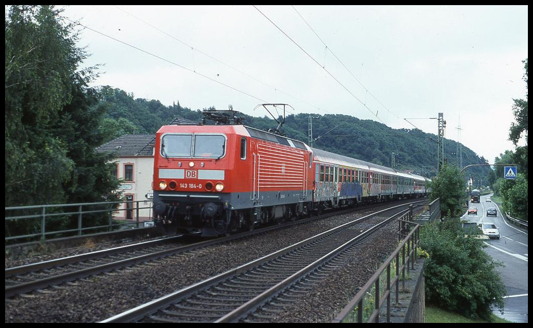 DB 143184-0 ist hier in Leubsdorf bei Bad Hönningen mit einer Garnitur Silberlinge am 10.7.2002 um 16.03 Uhr auf dem Weg nach Köln. Die Wagen sind so stark zu gesprayt, dass man ihr ursprüngliches Aussehen kaum noch erkennen kann.