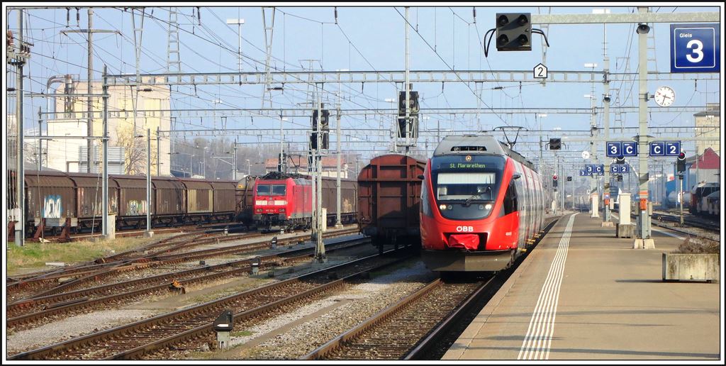 DB 185 124-5 wartet mit einem Ganzzug RedBull auf die Fahrt nach Konstanz  und 4024 033-5 erreicht als Vorarlberger S-Bahn den Grenzbahnhof St.Margrethen. (14.03.2014)