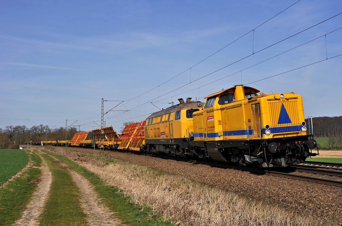 DB Bahnbau Gruppe 212 306 und 218 304 am 12.04.15 mit vormontierten Weichenteilen auf Schrgladewagen und mit Niederbordwagen in Richtung Osnabrck (Vehrte, 12.04.15).