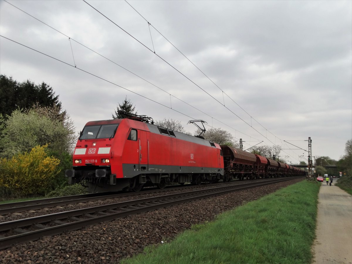 DB Cargo 152 117-8 am 07.04.17 mit langen Schotterwagenzug bei Maintal Ost