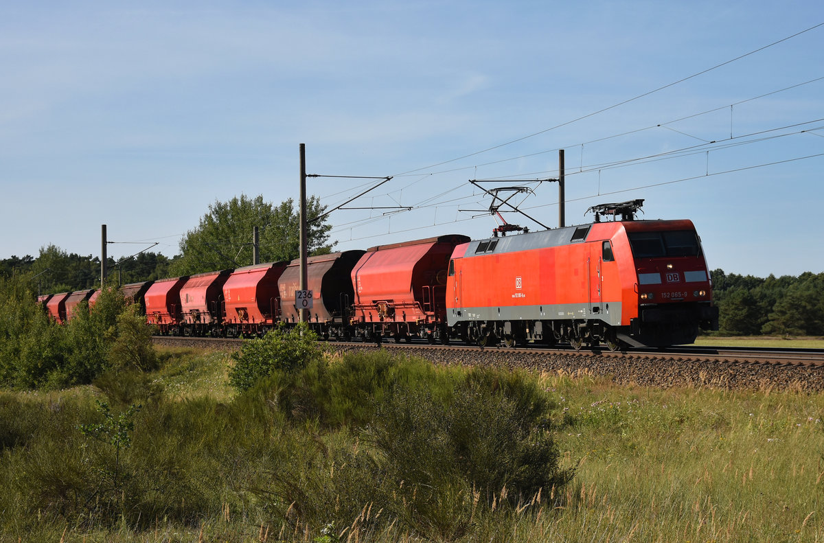 DB Cargo mit der 152 065-9 unterwegs mit Tanoos 31 80 Schüttgutwagen in Richtung Hagenower Land. 3km östlich von Büchen, 06.08.2018.