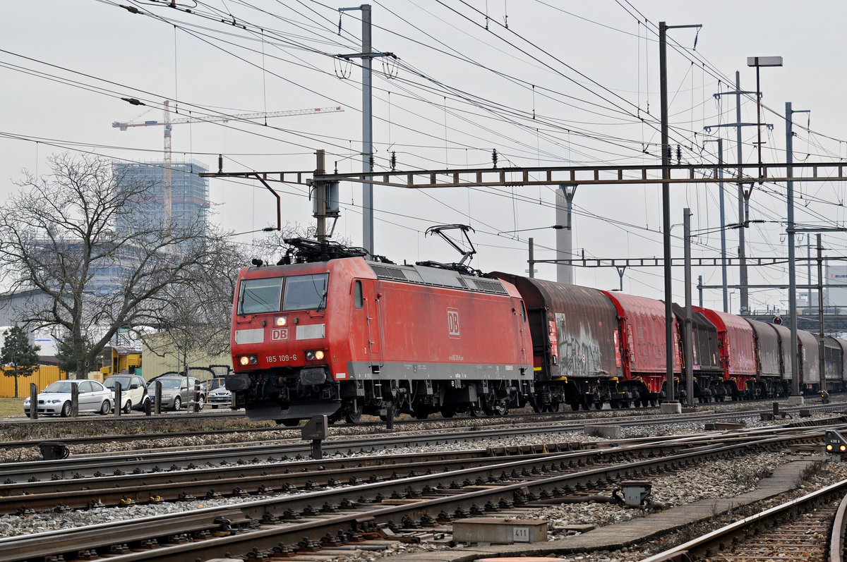 DB Lok 185 109-6 durchfährt den Bahnhof Pratteln. Das abzweigende Gleis führt auf eine Strasse und in ein Industriegebiet, von wo aus auch diese Aufnahme am 07.02.2017 entstand.