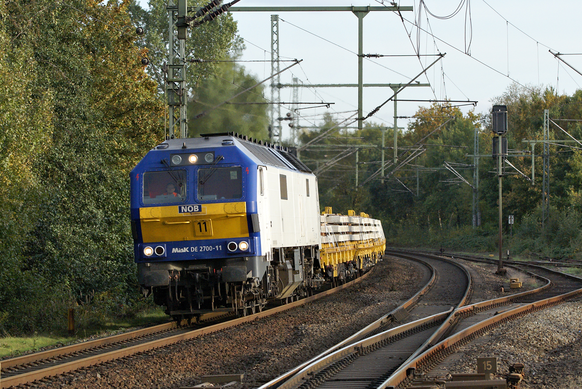 DE 2700-11 mit einem Schwellenzug Richtung Norden am 9.10.2009 in Tornesch. Normalerweise sind die Loks der Baureihe DE 2700 auf dieser Strecke vor Personenzügen der NOB im Einsatz.