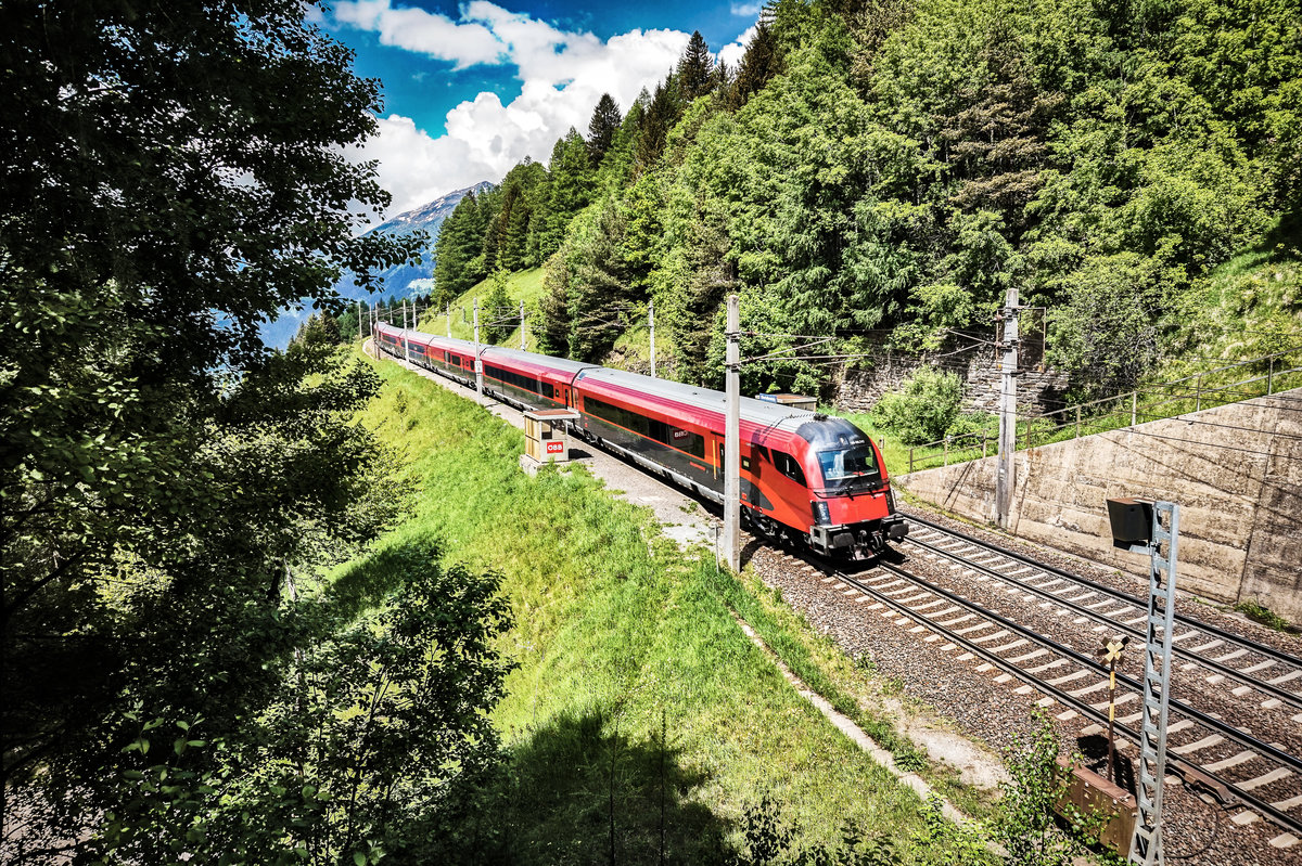 Der von 1116 247-8 geschobene railjet 111  Hohe Tauern  (München Hbf - Klagenfurt Hbf), durchfährt die Haltestelle Oberfalkenstein.
Aufgenommen am 13.5.2018.