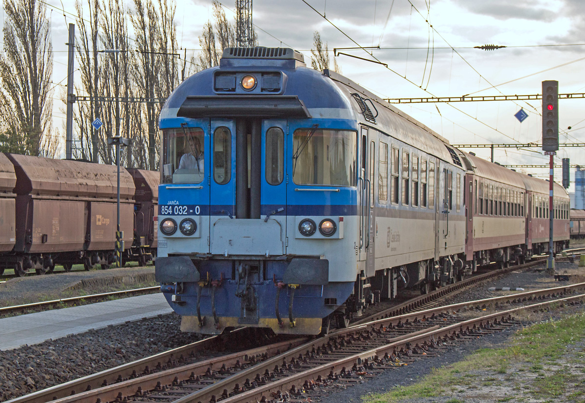 Der 854 032 ist am 12.10.2017 als R 1142  Svatopluk Čech  von Praha-Vršovice kommend zur Weiterfahrt nach Tanvald gerade bei der Einfahrt in den Bahnhof Všetaty. Die beiden angehängten Schnellzugwagen stellen derzeit die Regelbespannung dar. 