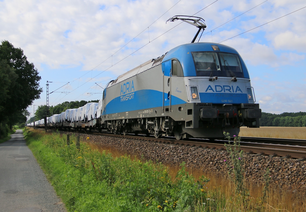 Der Adria Taurus 1216 921-7  Tamara  bespannte am 23.07.2015 einen Autotransportzug in Richtung Verden(Aller). Am Zugschluss hing noch die Wagenlok 185 677-2. Aufgenommen in Eystrup.