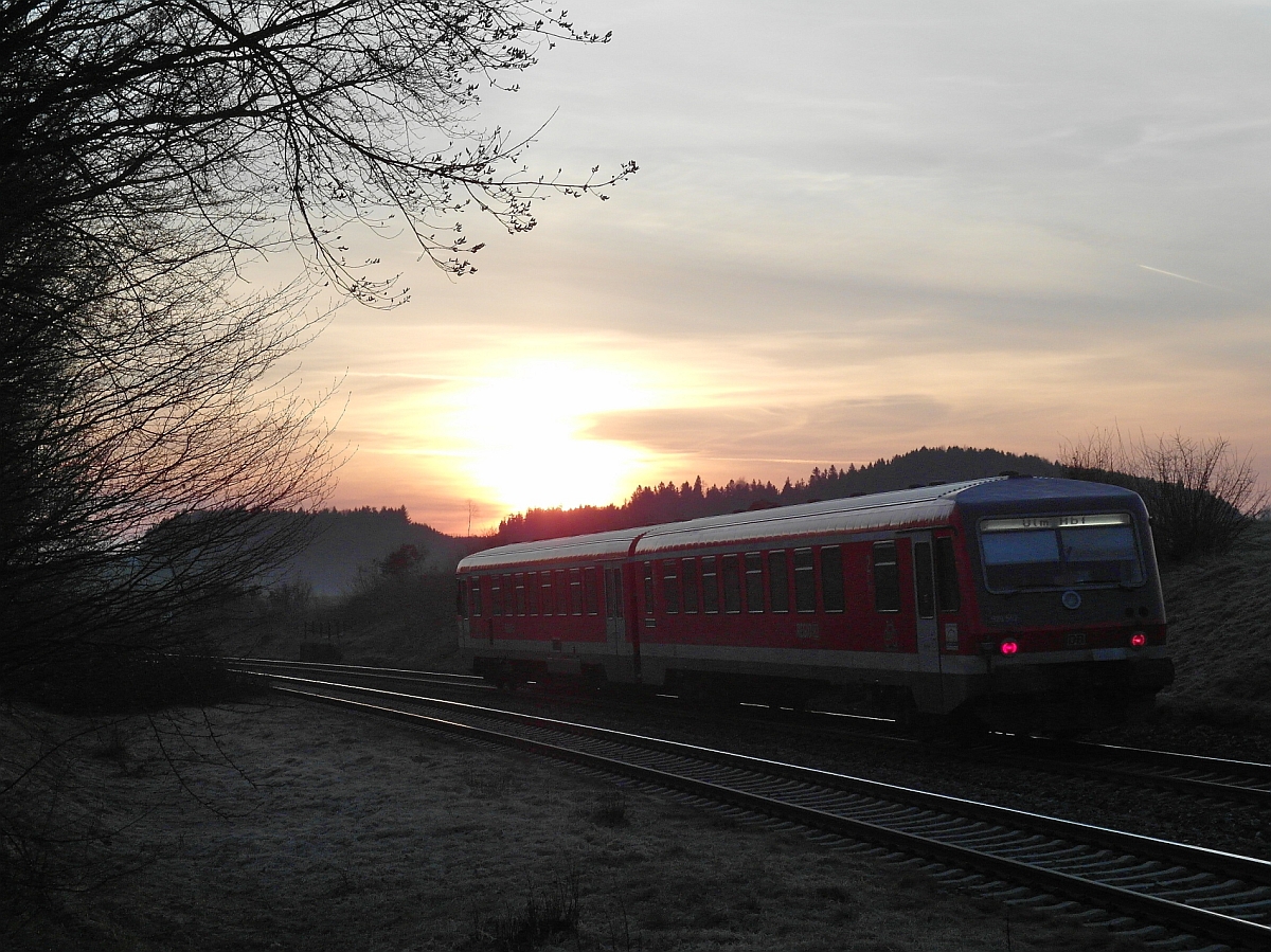 Der aufgehenden Sonne entgegen hat die RB 22606 von Aulendorf nach Ulm am 10.04.2015 bei Wattenweiler gerade die Wasserscheide zwischen Donau und Rhein passiert.