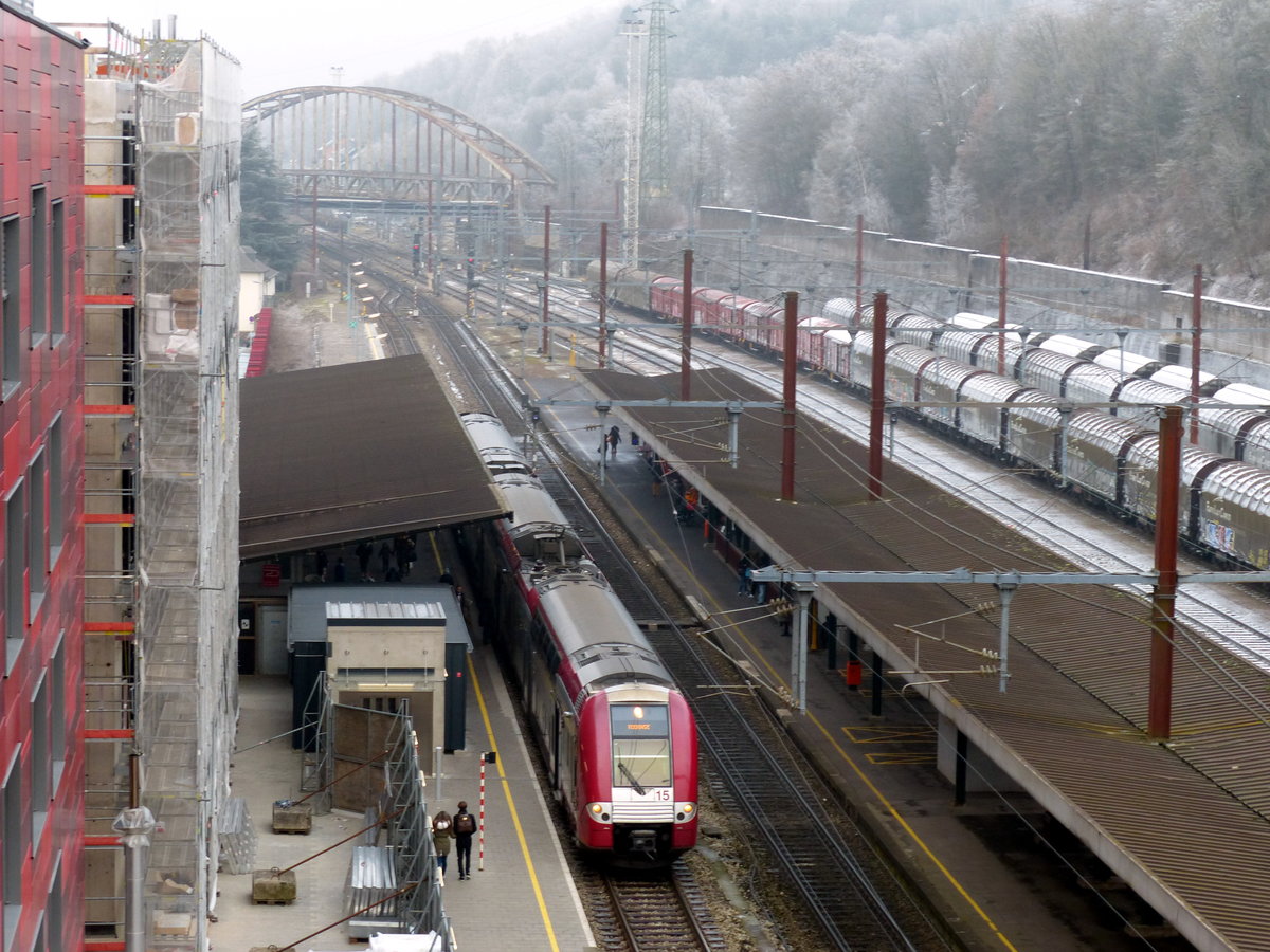 Der Bahnhof Esch-sur-Alzette ist mit einer per Fahrstuhl erreichbaren, sehr hohen Bahnbrücke verbunden, die in einen nahegelegenen Park mit Spieplatz und, etwas entfernt, zu einem kostenlosen Tierpark (Escher Déi'repark) führt. CFL 2215 nach Rodange fährt gerade aus. 31.12.2017, Esch