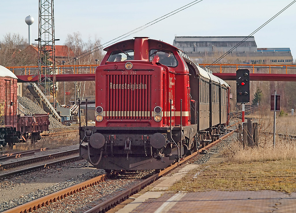 Der bis auf die Lokomotive 213 334 stilreine Sonderzug bestehend aus 3 Wagons Cid 21 und einem Packwagen konnte in dieser Form bis Anfang der 70er Jahre auf der Rennsteigbahn angetroffen werden, zuerst mit T26, einer Zahnstangenlok, später dann mit einer T16.1 oder eben mit einer 6-achsigen V180, die zwar keine hydrodynamische Bremse hatte aber trotzdem für die Steilstrecke zugelassen war.
Am 27.03.2016 wird dieser Sonderzug in Ilmenau für die Fahrt über den Rennsteig nach Schleusingen bereit gestellt, schön vorgewärmt, auch die Dampfheizung in Lok und
Wagen funktioniert noch gut.