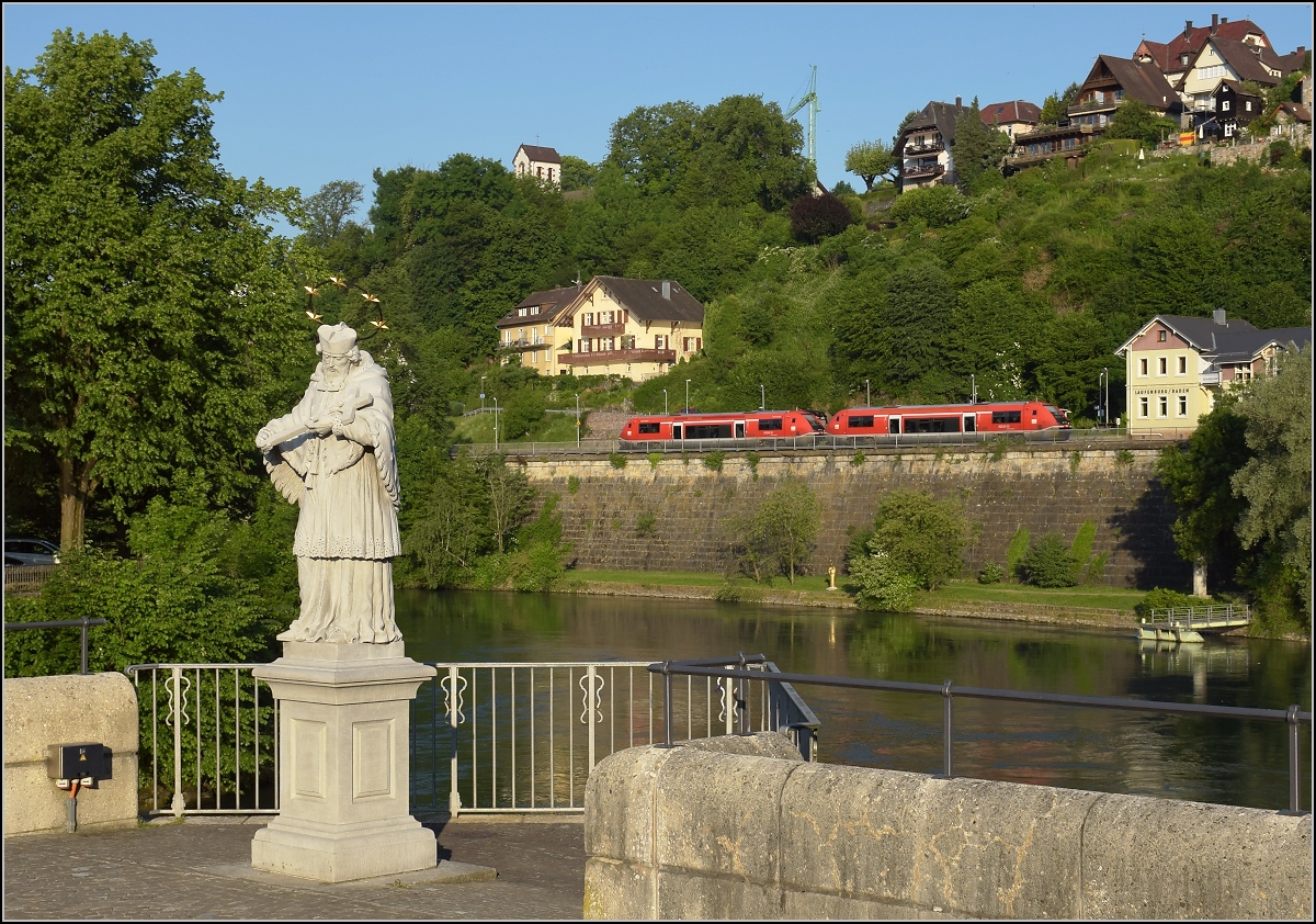 Der Brückenheilige Nepomuk steht als Grenzstein zwischen den beiden  Laufenburgs  während im Hintergrund zwei  Rotwale  (641 005 und 641 012  Lauchringen ) Fahrgäste einsammeln. Mai 2017.