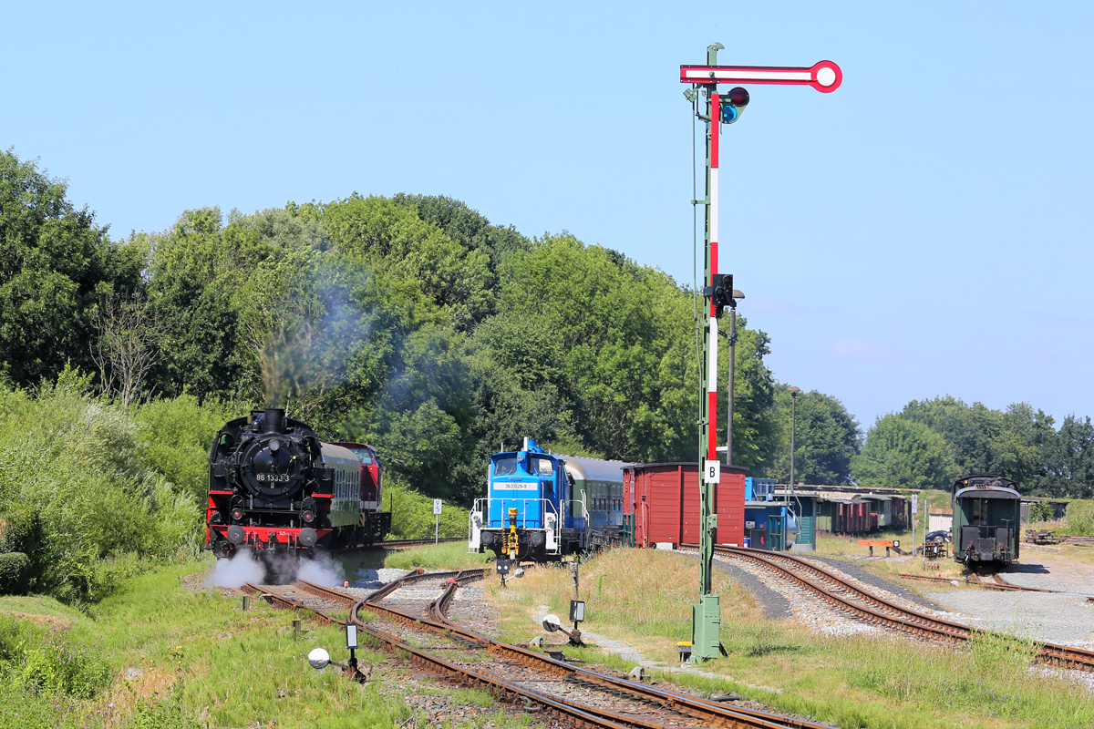 Der gerade am Ausfahrsignal B in Putbus vorbeigefahrene historische Zug mit der Schlusslok 86 1333 und der Zuglok 204 271 auf Höhe der Lok 363 029 mit weiteren historischen Wagen. - 06.07.2018