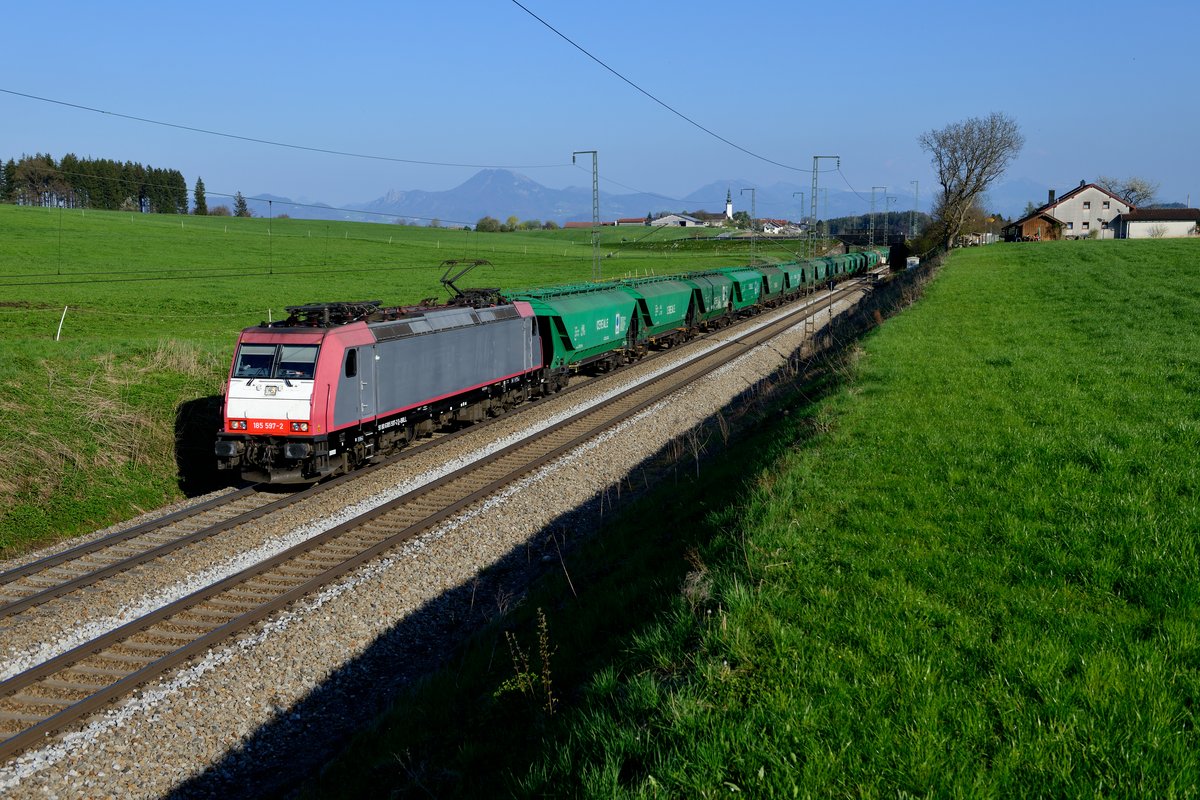 Der interessanteste Zug des Tages war der DGS 45192. Gebildet wurde der Getreidezug aus rumänischen Wagen der Gattung Uagps. Geführt wurde er von der lange Zeit an Crossrail vermieteten 185 597, die zum Aufnahmezeitpunkt erst seit wenigen Tagen für die HSL eingesetzt wurde. Das ursprüngliche Farbschema trägt die Maschine noch, die Beschriftung wurde zwar entfernt, läßt sich aber noch erahnen. Aufgrund von Bauarbeiten im Bahnhof Passau wurde der Zug über Freilassing umgeleitet. Bei Hörafing wurde der Auslöser betätigt. Im Hintergrund die Salzburger Hausberge, die gegen Abend klarer erkennbar wurden (09. April 2017).