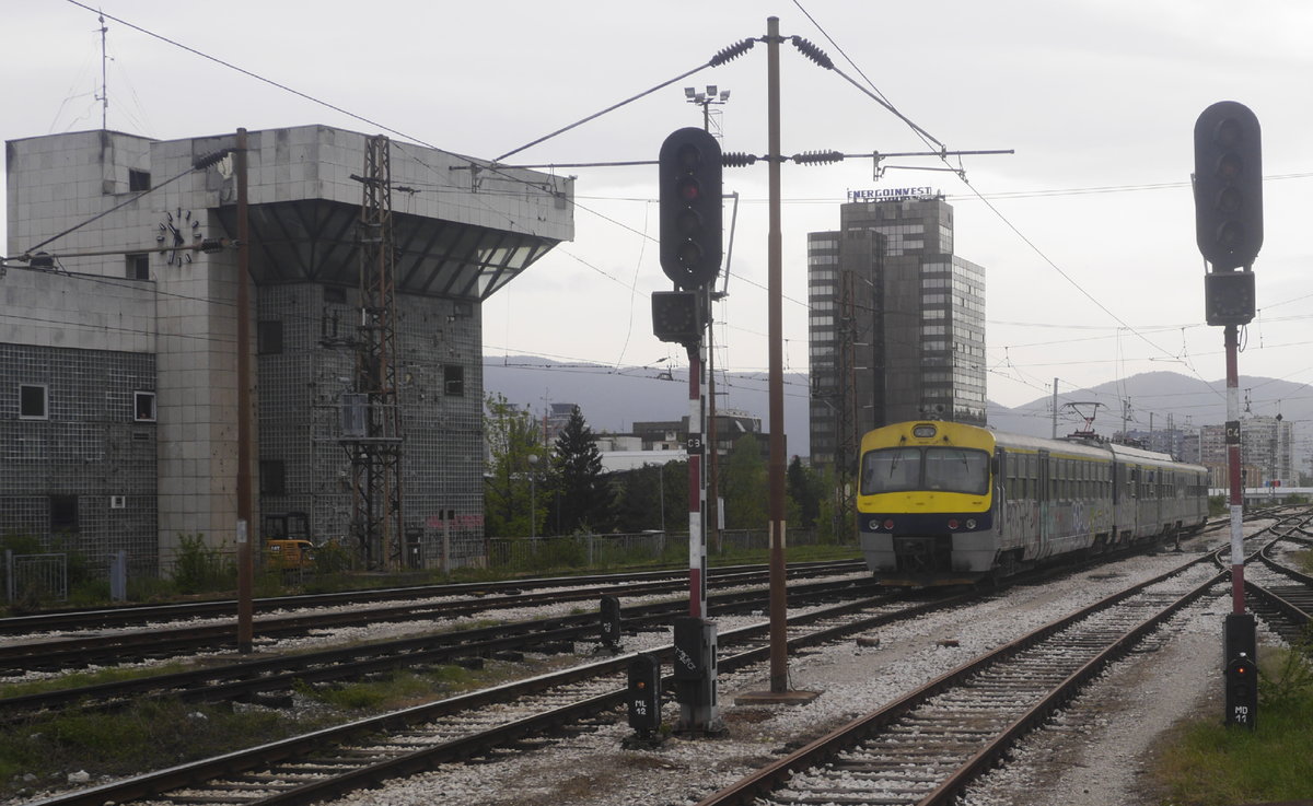 Der nachmittägliche Lokalzug nach Kakanj passiert bei seiner Ausfahrt aus Sarajevo das längst außer Betrieb gesetzte Zentralstellwerk. Auch die Signale sind funktionslos. Die Ausfahrt erfolgt auf schriftlichen Befehl. Aufnahme vom 27.4.17.