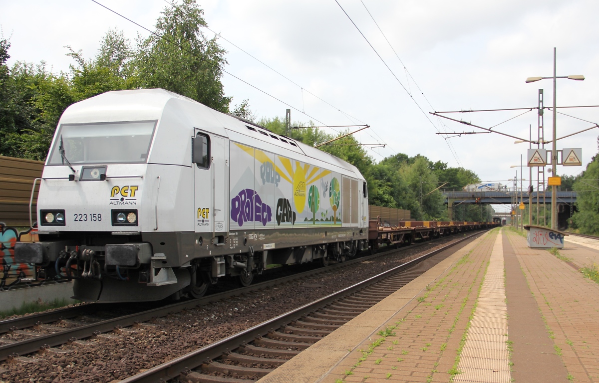 Der PCT Herkules 223 158 mit leeren Flachwagen in Fahrtrichtung Seelze. Aufgenommen am 10.07.2013 in Dedensen-Gümmer.
