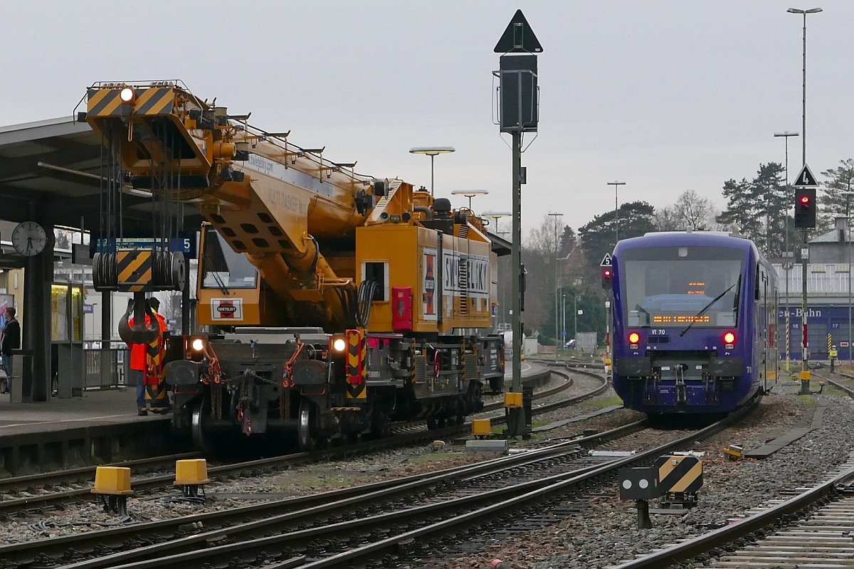 Der von SWIETELSKY eingesetzte Gleisbauschienenkran KRC 1600 Multi Tasker (D-RTS 99 80 9419 011 - 8) auf Gleis 5 des Friedrichshafener Stadtbahnhofes (22.03.2017). Aufnahme entstand vom zwischen den Gleisen und der Wohnbebauung entlangführenden öffentlichen Fußweg.