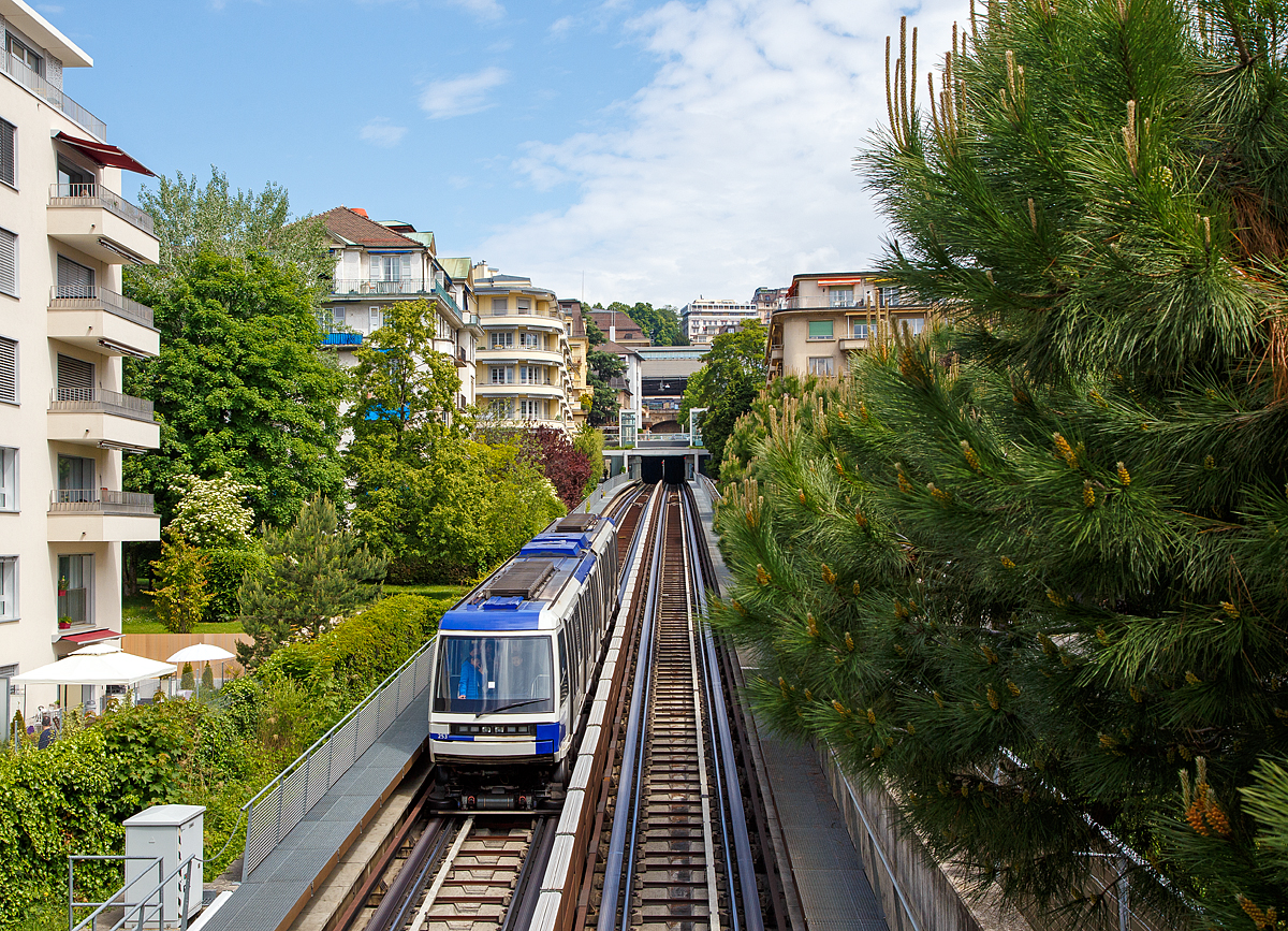 
Der Triebwagen 253 der Métro Lausanne bzw. U-Bahn Lausanne (Linie m2) fährt am 21.05.2018 nach Lausanne-Ouchy hinab, hier kurz vor der Station Délices (408 m). Allein der Höhenunterschied zwischen den Endstationen Ouchy (unten am See gelegen) und dem SBB Bahnhof Lausanne beträgt 79 m.

Die U-Bahn Lausanne (m2) ist eine 5,9 km lange U-Bahn-Linie in Lausanne, welche von Ouchy (373 m) am Ufer des Genfersees über den Bahnhof Lausanne und das Stadtzentrum nach Epalinges-Croisettes (711 m) führt. Sie weist den größten Höhenunterschied aller U-Bahnen der Welt auf, obwohl einige Streckenabschnitte (wie hier) offen verlaufen. Die 2008 eröffnete Linie entstand aus dem Umbau der Zahnradbahn Lausanne–Ouchy. Zusammen mit der Stadtbahn Lausanne (Linie m1) werden die beiden Linien als Métro Lausanne bezeichnet. Sie ist die erste und einzige U-Bahn in der Schweiz. Betreiber beider Linien ist die Transports publics de la région lausannoise, abgekürzt TL (zu Deutsch: Öffentlicher Verkehr der Region Lausanne).

Die U-Bahn-Strecke ist 5,9 Kilometer lang und umfaßt 14 Stationen, wovon vier bereits bestanden. Es gibt vier Tunnelabschnitte, die eine Gesamtlänge von 5,3 Kilometern aufweisen. 600 m der Strecke verlaufen außerhalb von Tunneln. Der Höhenunterschied zwischen den Endstationen Ouchy (unten am See gelegen) und dem am Hügel gebauten Vorort Croisettes beträgt 336 Meter, wobei die durchschnittliche Steigung 5,7 %, die Maximalsteigung 12 % beträgt. Die Linie m2 weist damit den größten Höhenunterschied aller U-Bahnen der Welt auf, sie ist auch die steilste Adhäsions-U-Bahn sowie die weltweit dritt steilste U-Bahn – nach der Karmelit in Haifa (eine pneubereifte Standseilbahn mit 30 % Steigung) und der Métro C in Lyon (eine Zahnradbahn mit bis zu 17 % Steigung).

Strecke:
Die bereits bestehende Strecke der Zahnradbahn beginnt in Ouchy am Ufer des Genfersees, wobei das unterste Teilstück, das zuvor in einem Einschnitt verlief, in den Untergrund verlegt wurde. Die bestehende Station Montriond ersetzte man durch die Stationen Délices und Grancy. Oberhalb von Grancy beginnt der zweite Tunnel, der den Hauptbahnhof unterquert und zur bisherigen Endstation Flon führt. Dort besteht eine Umsteigemöglichkeit zur Stadtbahn m1 nach Renens und zur Chemin de fer Lausanne-Echallens-Bercher (LEB).

Oberhalb der Station Flon beginnt der Neubauabschnitt. Hinter der Station Riponne endet der zweite Tunnel, da die Strecke auf einer Brücke ein tief eingeschnittenes Tal im Stadtzentrum überquert. Der dritte Tunnel endet kurz vor La Sallaz. Nördlich dieser Station folgt der vierte Tunnel bis zur Endstation. Da die Station Vennes direkt an der Autobahn A9 liegt, entstand dort ein großer Park-and-ride-Platz. Vennes ist auch Standort des Depots und der Betriebswerkstatt. Die Strecke endet in Croisettes am Ortsrand von Epalinges.

Betrieb:
Beim Betrieb der U-Bahn wird auf französische Technik von Alstom gesetzt. Die 15 zweiteiligen Einheiten sind jeweils 30,68 m lang, 2,45 m breit und 3,47 m hoch, sie können maximal 351 Fahrgäste aufnehmen. Die erste Einheit wurde am 2. September 2006 nach Lausanne geliefert, die übrigen folgten im Abstand von zwei Monaten.

Die Linie m2 wird führerlos und vollautomatisch befahren, die Bahnsteige besitzen Türen, die gleichzeitig mit den auf gleicher Höhe befindlichen Fahrzeugtüren geöffnet und geschlossen werden. Das Prinzip von Fahrbahn und Führung wurde von der Pariser Métro übernommen. Auch die von Alstom gefertigten Fahrzeuge entsprechen weitestgehend der Pariser Pneumetro Typ MP89 CA. Allerdings bestehen Lausanner Einheiten lediglich aus zwei Wagenkästen, sie werden als Be 8/8 TL (Triebwagen TL 241 bis 258) geführt. Wie auf einigen Linien der Pariser Metro, sind die Drehgestelle mit gummibereiften Rädern ausgestattet. Damit ersparte man sich die Montage einer Zahnstange im Gleis. Die Bergfahrt für die gesamte Strecke dauert 21 und die Talfahrt 18 Minuten. Die Zufuhr der Elektrizität erfolgt über die als Stromschienen mitbenutzten seitlichen Führungsschienen.

Spezifikationen der Alstom Be 8/8 TL (Triebwagen TL 241 bis 258)

Die Züge haben vier Drehgestelle mit je zwei Achsen. Jedes Drehgestell hat seinen eigenen Motor mit einer Leistung von 314 kW, was eine Gesamtleistung von 1.256 kW ergibt. Sie werden bei einer Spannung von 750 V Gleichstrom durch eine dritte Schiene mit Strom versorgt und können eine Höchstgeschwindigkeit von 60 km/h  erreichen. Der Drehzapfenabstand zwischen den äußeren und inneren Drehgestellen ist 10 m und der Drehzapfenabstand zwischen den inneren Drehgestellen ist 4,88 m.

Jeder Zug hat 36 Sitze und 20 Klappsitze. Diese Züge fahren automatisch (fahrerlos). Für Manövriervorgänge z.B. im Depot steht manuelles Bedienfeld für zur Verfügung.

TECHNISCHE DATEN der Be 8/8 TL:
Hersteller: Alstom
Baujahr: 2006
Anzahl: 15 (Triebwagen Nr. 241 bis 258)
Fahrzeugtyp: Bi-directional
Spurweite: 1.435 mm (Normalspur) Gummi bereift 
Achsfolge: Bo'Bo' + Bo'Bo'
Länge über Alles: 30.680 mm (2x 15.340 mm)
Breite: 2.450 mm
Höhe: 3.473 mm
Gewicht: 57,3 t
Anzahl der Türen: 6 (je Seite)
Einstiegshöhe: 1.905 mm
Fußbodenhöhe: 1.130 mm
Höchstgeschwindigkeit: 60 km/h
Leistung: 4 x 314 kW = 1.256 kW
Stromsystem: 750 V DC (Gleichstrom über Stromschiene)
Kleister befahrbarer Gleisbogen: 40 m
Maximalsteigung: 12 %

Quellen: Wikipedia (deutsch und französisch), sowie Alstom
