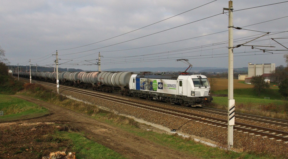 Der Vectron 193 813-3 von Railpool ``Rail Service`` ist am 21.11.2014 mit einem Kesselzug auf der Westbahn Richtung Wien unterwegs. Hier im Wechselverkehr wegen einer Überholung des REX nach Wien West. Für den Güterzug ist ein kurzer Halt in Böheimkirchen notwendig. Aufgenommen am Misthaufen kurz vor Böheimkirchen.