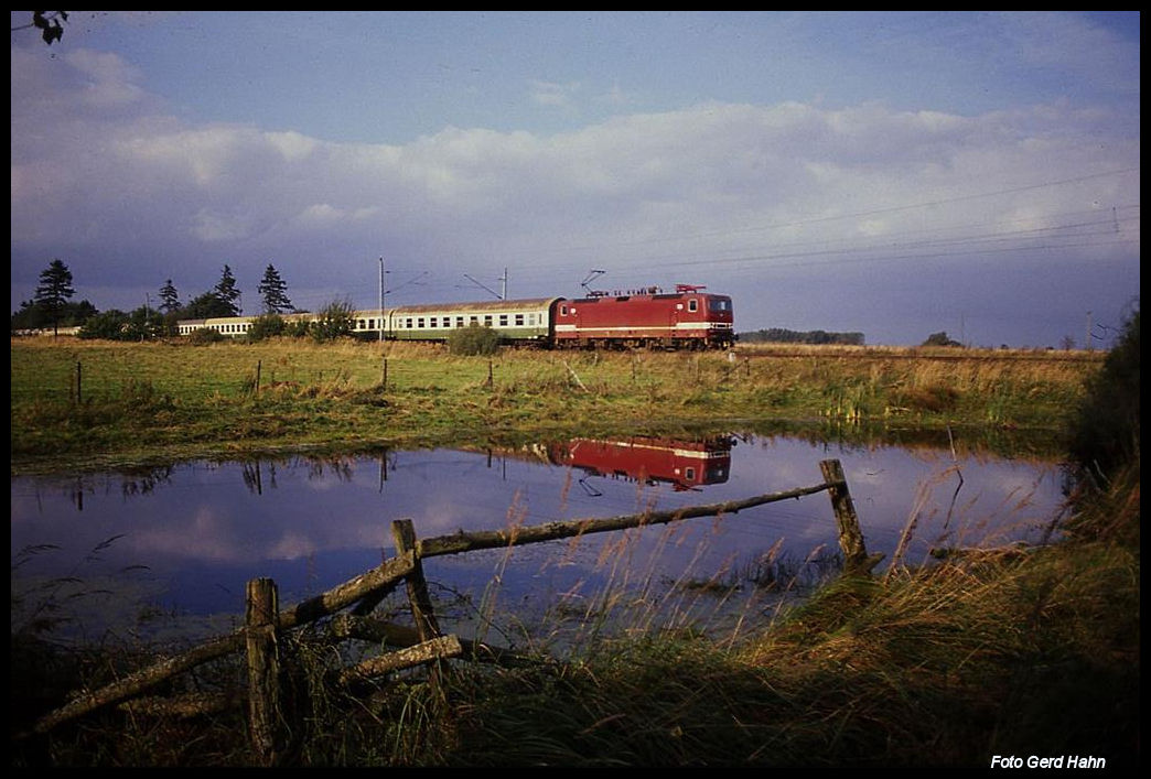 Deutlich spiegelt sich die 243361 in einem Wiesen Weiher bei Kilomter 2,15 nahe Greifswald. Die Lok ist hier mit dem D 546 am 4.10.1991 um 14.18 Uhr unterwegs nach Greifswald.