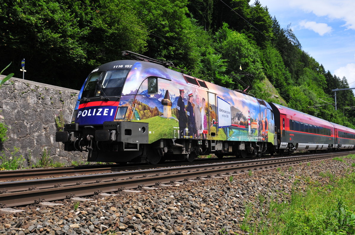 Die 1116 157 der ÖBB  Gemeinsam Sicher  vor einem Personenzug kurz vor der Einfahrt in den Bahnhof Kufstein am 11.07.17