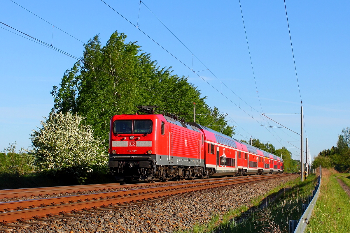 Die 112 107 mit dem RE 5 von Wünsdorf-Waldstadt nach Stralsund Hbf am 06.05.2018 in Nassenheide.