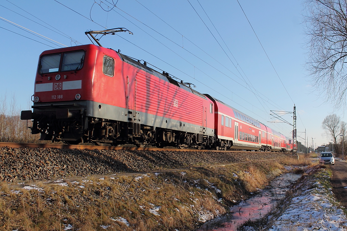 Die  112 188 schiebt den RE 3513 von Stralsund Hbf nach Elsterwerda am 06.02.2018 durch Nassenheide.