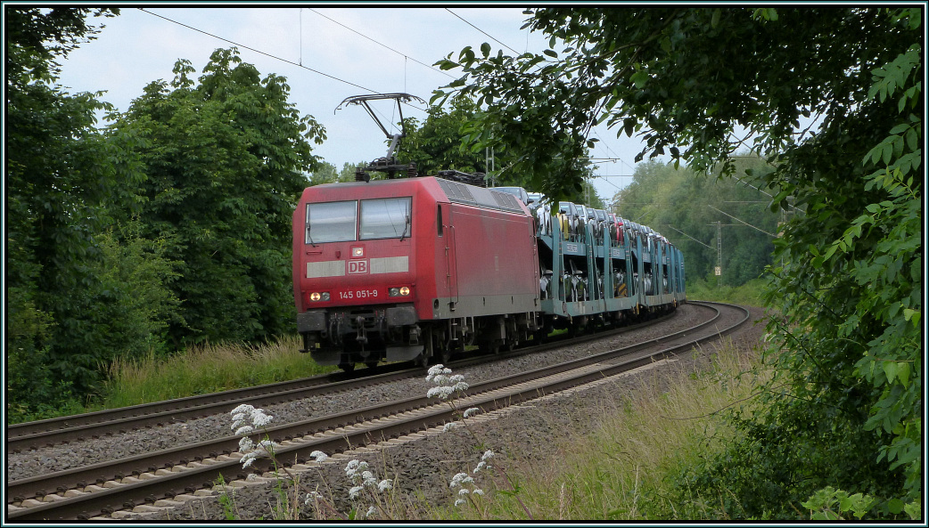 Die 145 051-9 ist mit einen Autotransportzug unterwegs nach Aachen West.Hier zu sehen in Rimburg bei bach Palenberg auf der Kbs 485 im Juli 2013.