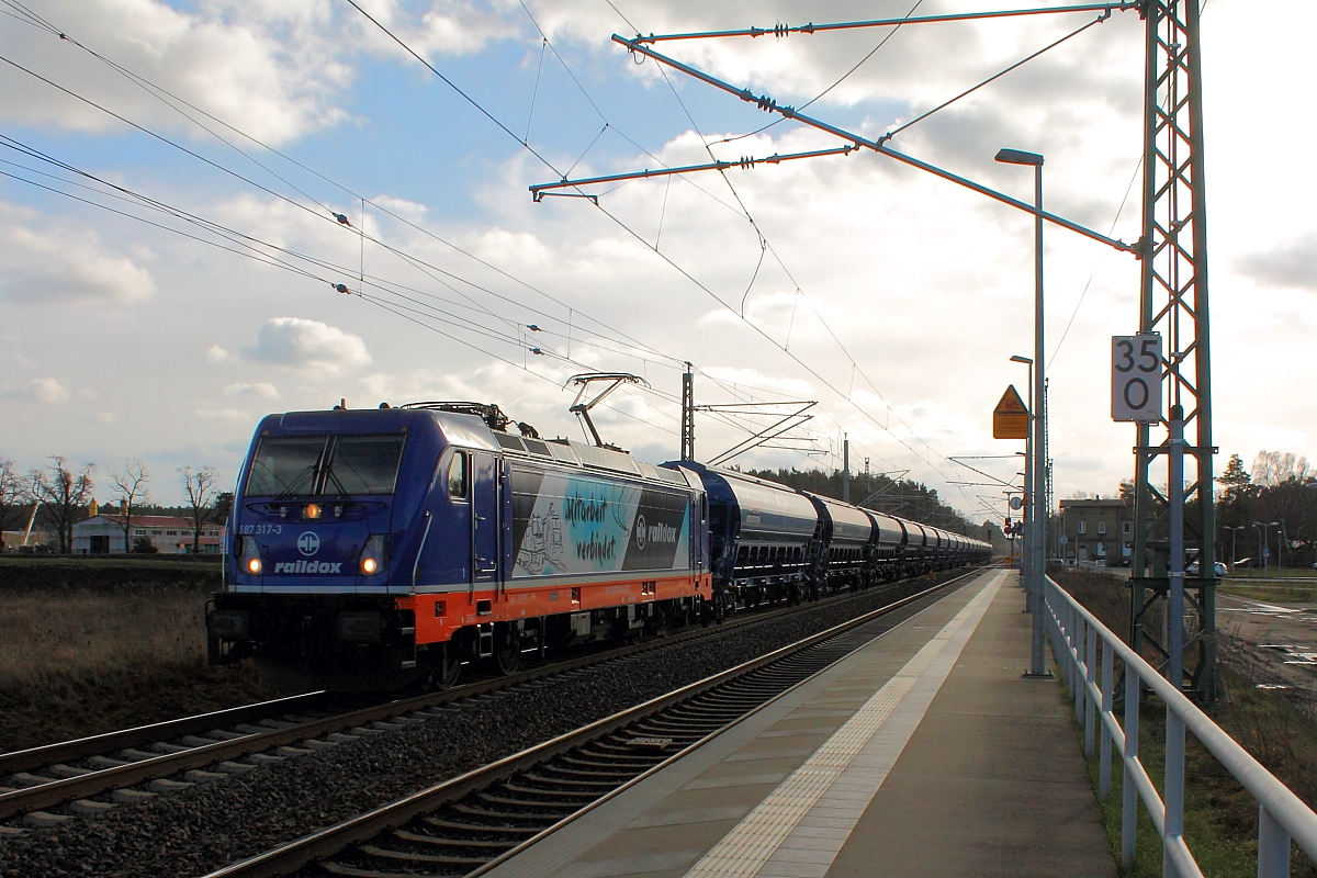 Die 187 317-3 der Raildox „Mitarbeit verbindet“ mit einem Ganzzug am 01.02.2018 in Nassenheide.