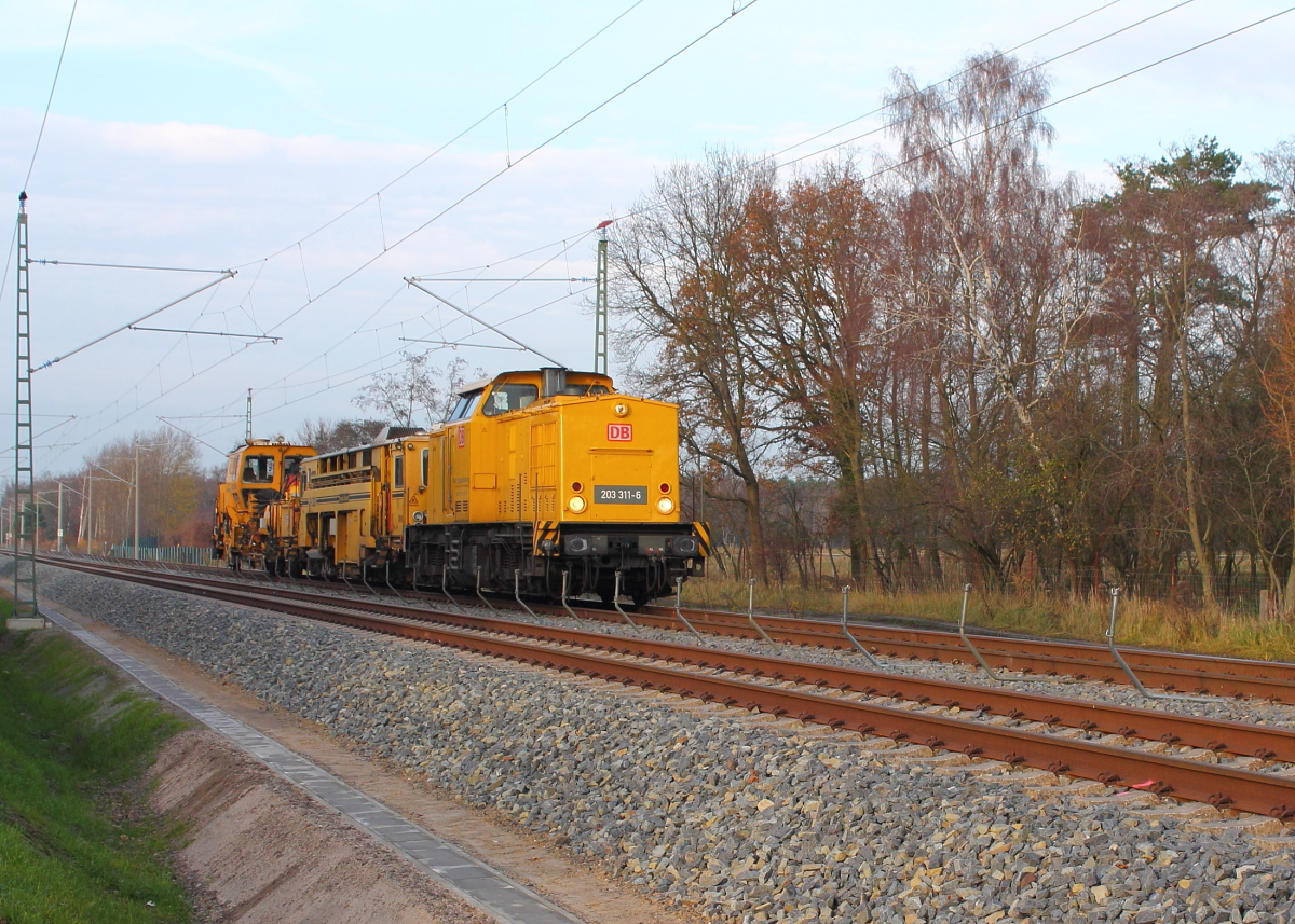 Die 203 311-6 der DB Netzinstandhaltung mit einer Universalstopfmaschine 08-32 U und einer Schotterprofiliermaschine SSP 2000 im Schlepp bei der Durchfahrt am 19.11.2013 in Nassenheide.