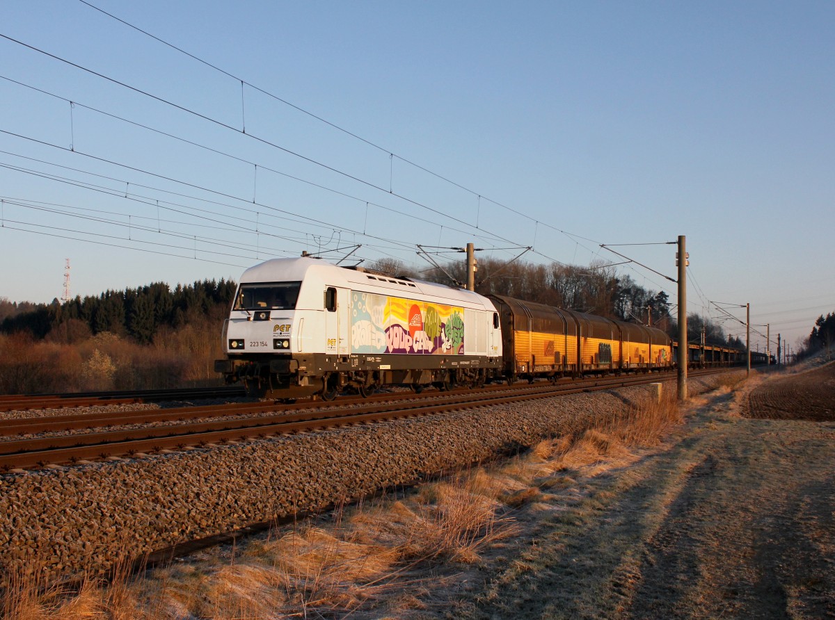 Die 223 154 mit einem leeren Autozug am 07.04.2015 unterwegs bei Unterweilbach.