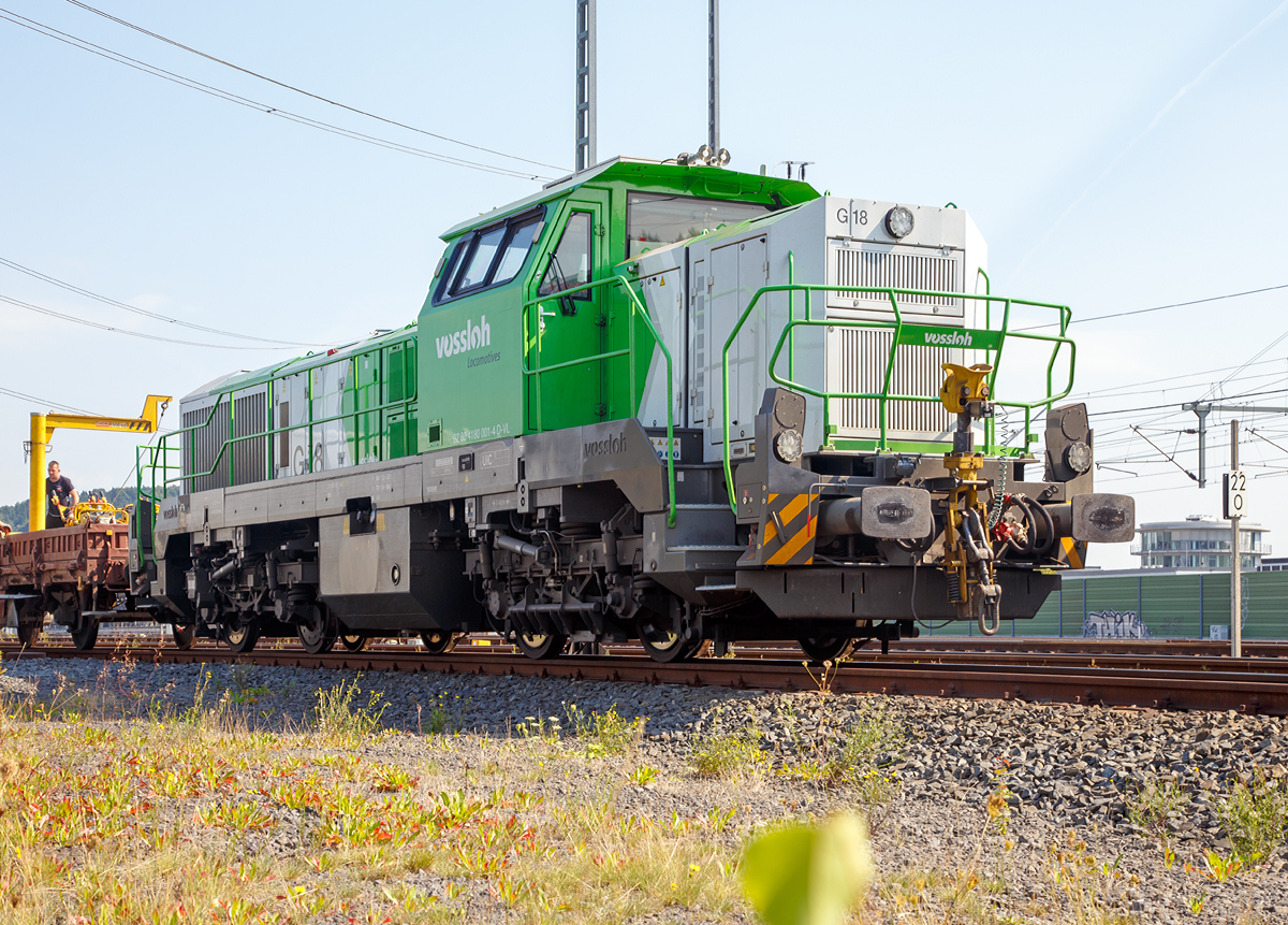 
Die an die SLG Spitzke Logistik GmbH vermietete und der Vossloh Locomotives GmbH gehörende G 18 (92 80 4180 001-4 D-VL) im am 12.09.2015, mit einem  Langschienenzug, beim ICE-Bahnhof Montabaur abgestellt. 

Die Lok wurde 2011 von Vossloh in Kiel unter der Fabriknummer 5001927 gebaut.

Die G 18 wie auch die G 12 sind neue dieselhydraulische Lokomotiven für den Rangier- und Güterzugdienst von Vossloh Locomotives.  Die G 12 mit 1.200 kW sowie die G 18 mit 1.800 kW. Angetrieben werden die Vierachser von den optimierten Turbo-Flex-Getrieben L530breU2 von Voith. Ein neues Drei-Wandler-Getriebe verbessert den Wirkungsgrad und ist mit einem leistungsfähigen Retarder zum verschleißfreien Bremsen ausgerüstet. Das Gesamtgewicht der Loks kann flexibel zwischen 80 und 90 t ausgelegt werden. 

Von der G 18 sind derzeit 3 Loks gebaut worden, diese ist die erste Lok von diesem Typ.

Technische Daten:
Spurweite:  1.435 mm
Achsanordung:  B‘B‘
Höchstgeschwindigkeit: 120 km/h
Dieselmotorleistung:  max. 1.800 kW
Dieselmotor:  MTU 12V 4000 R43 (L)
Dieselmotordrehzahl  1.800 min-1
Abgasvorschriften:  EU/2004/26 Stufe IIIA/prepared for stage IIIB  
Anfahrzugkraft:  291 kN
Dienstgewicht:  80 t
Raddurchmesser:  1.000 mm (neu) / 920 mm (abgenutzt)
Länge über Puffer : 17.000 mm  
Größte Höhe:  4.310 mm  
Größte Breite:  3.080 mm
Strömungsgetriebe:  Voith L 530 breU2
Hydrodynamische Bremsleistung:  max. 1.600 kW
Kleinster befahrbarer Bogenradius:  55 m

