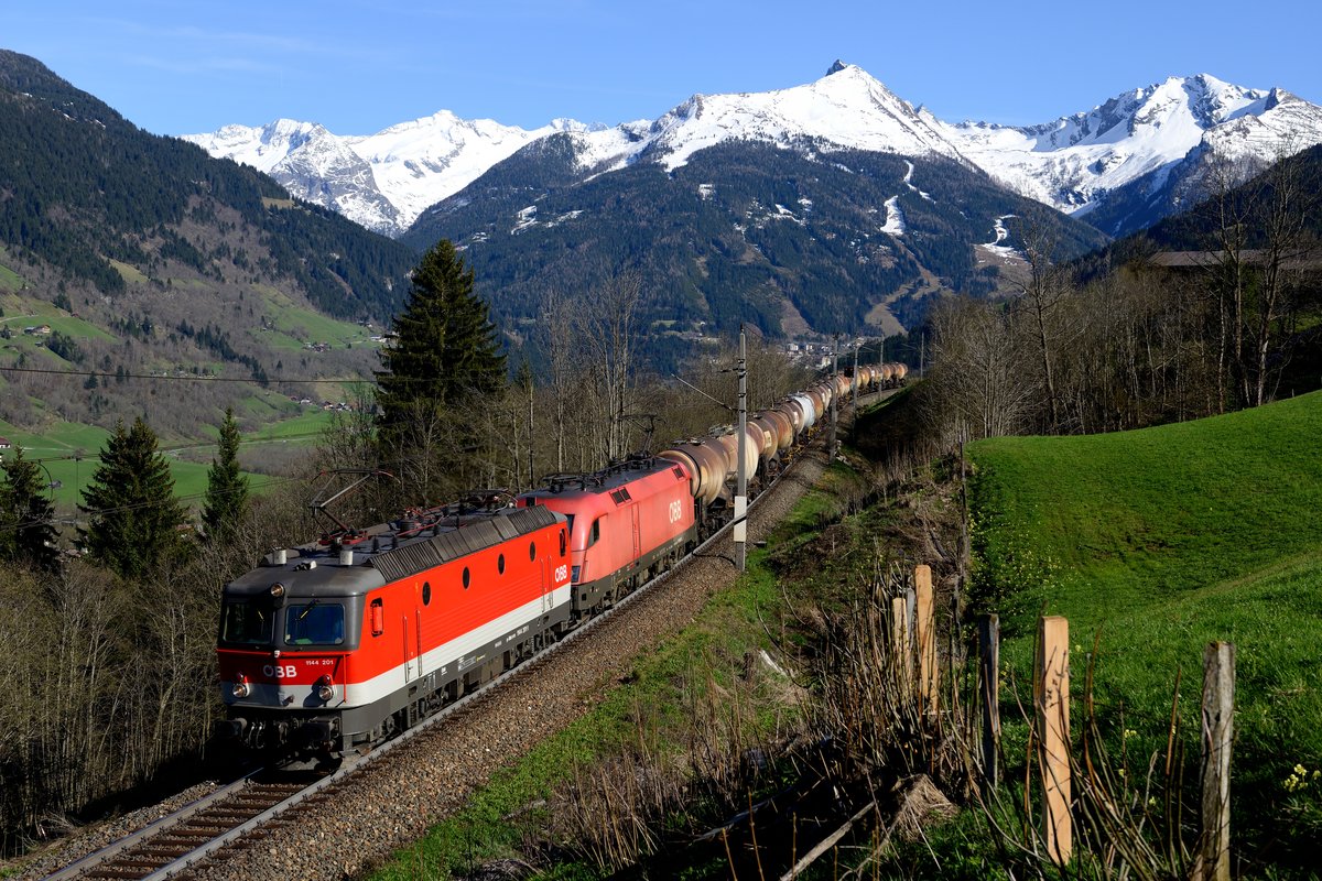 Die bestens gepflegte 1144.201 und eine 1116 befinden sich bei Anger mit G 48714, gebildet aus Kesselwagen für Kreideschlamm, auf Talfahrt in Richtung Bad Hofgastein (24. April 2013).
