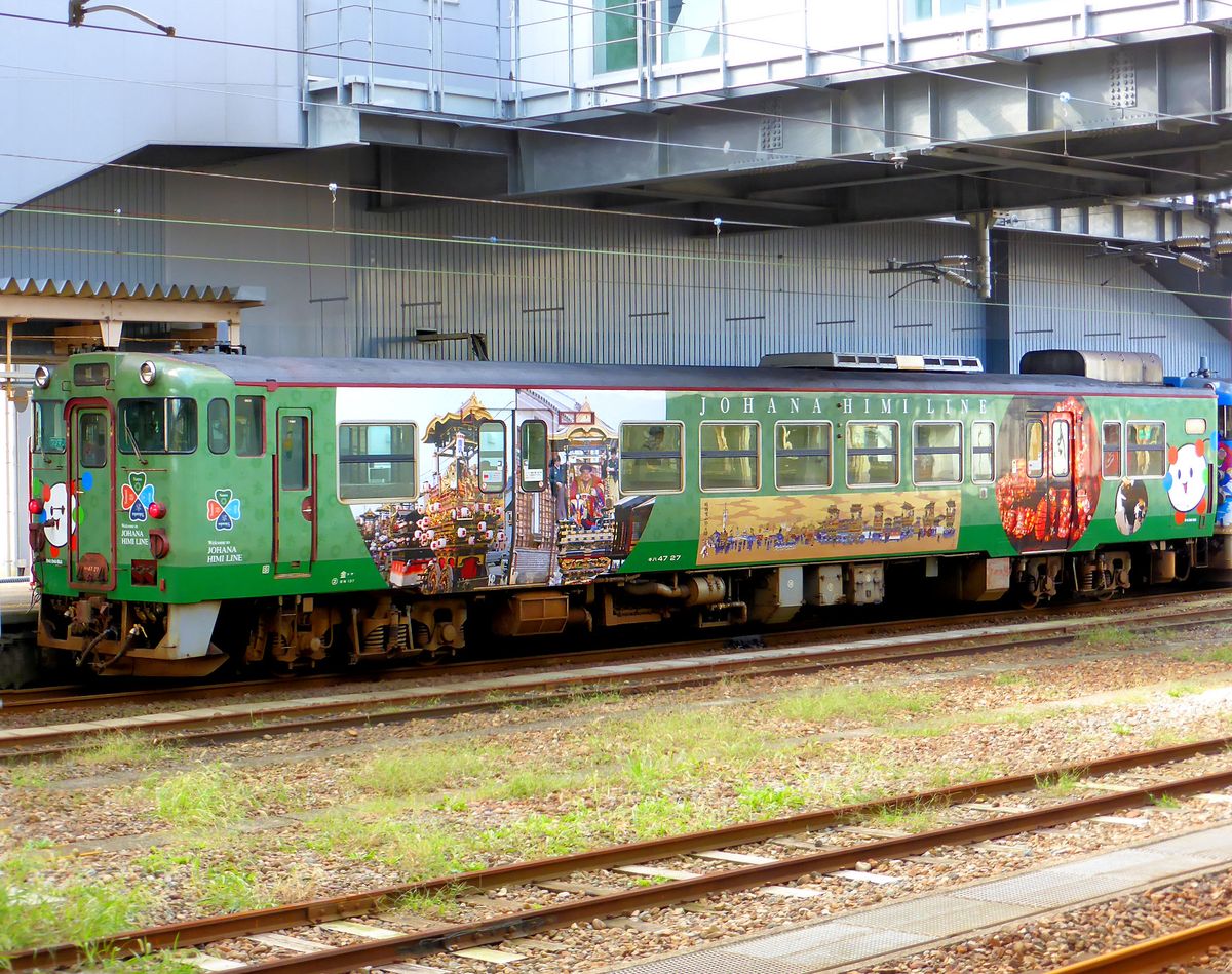Die bunten Triebwagen der Region Takaoka: Triebwagen KIHA 47 27 mit seinem grossen Bild vom Götterwagenfest, und in der Mitte ein historisches Bild eines derartigen Festumzugs vor vielen hundert Jahren. Takaoka, 23.Oktober 2013. 