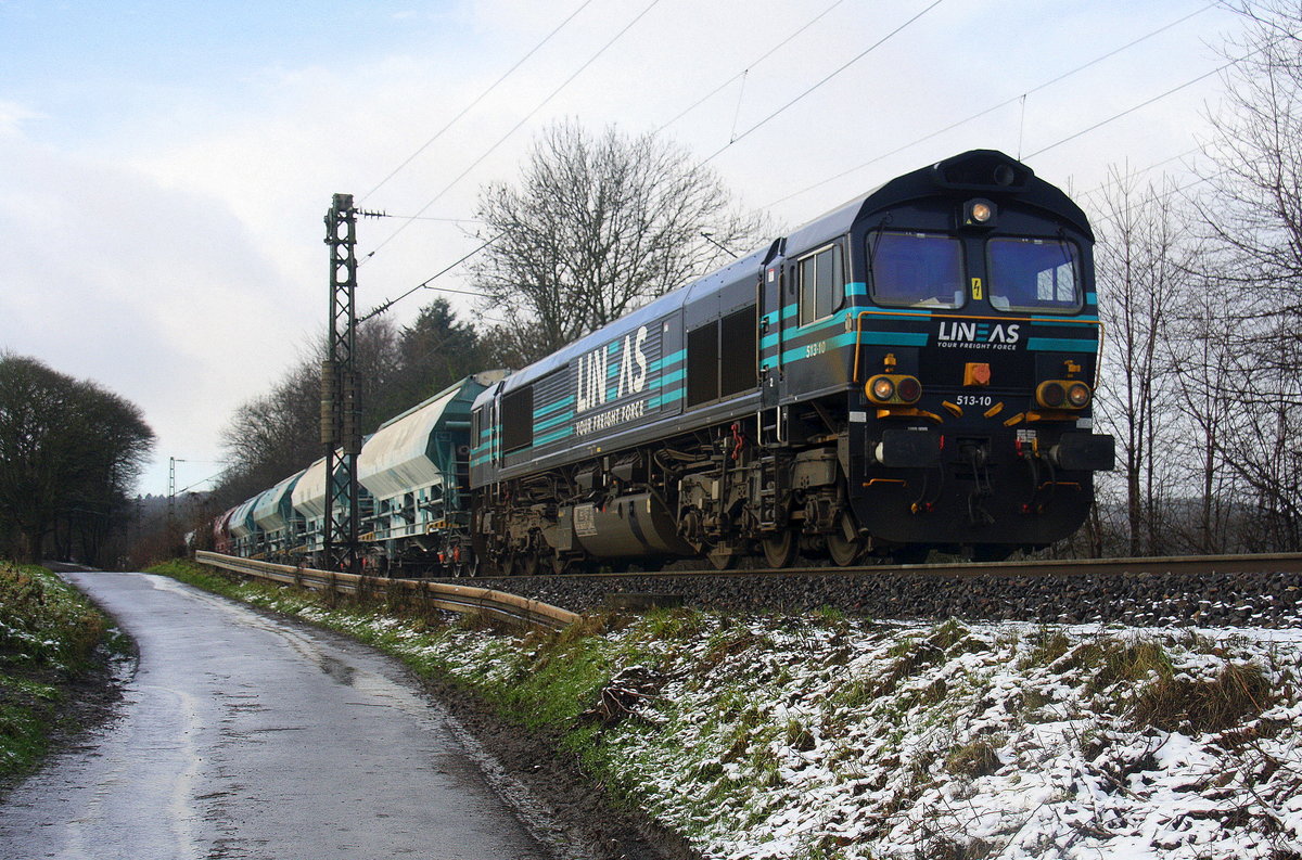 Die Class 66 513-10 von Lineas  kommt die Gemmenicher-Rampe herunter nach Aachen-West mit einem  schweren Kalkzug aus Hermalle-Huy(B) nach Oberhausen-West(D). 
Aufgenommen an der Montzenroute am Gemmenicher-Weg. 
Bei Sonne und Schnee am Kalten Morgen vom 28.12.2017.