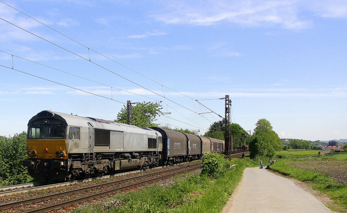 Die Class 66 6612 von Railtraxx grüßt mit Hupe und kommt die Gemmenicher-Rampe hochgefahren mit einem schweren Coilzug aus Linz Voestalpine(A) nach Antwerpen Waaslandhaven(B) am Ende ist eine 185 511-3 von Metrans  fährt als Schubhilfe und schiebt von Aachen-West bis zum Gemmenicher-Tunnel. Aufgenommen an der Montzenroute am Gemmenicher-Weg. 
Bei schönem Frühlingswetter am 14.5.2015.