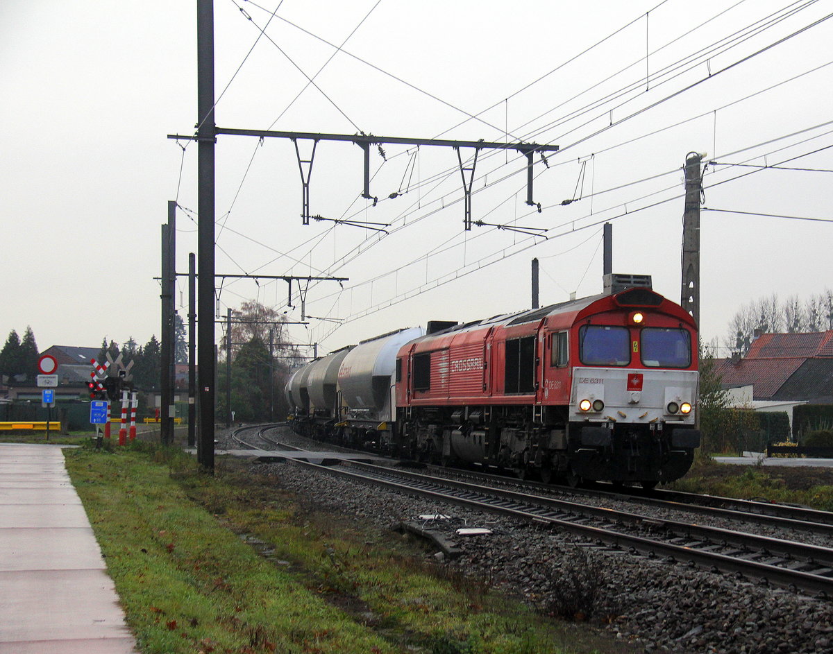 Die Class 66 DE6311  Hanna  von Crossrail kommt mit einem Silozug aus Herentals(B) nach Buna-Werke(D) und kommt aus Richtung Hasselt(B) und fährt durch Hoeselt(B) in Richtung Tongeren(B),Vise(B),Montzen(B),Aachen(D).
Aufgenommen von einem Fußgängerweg in Hoeselt(B).
Bei Regenwetter am Nasskalten Nachmittag vom 24.11.2018.