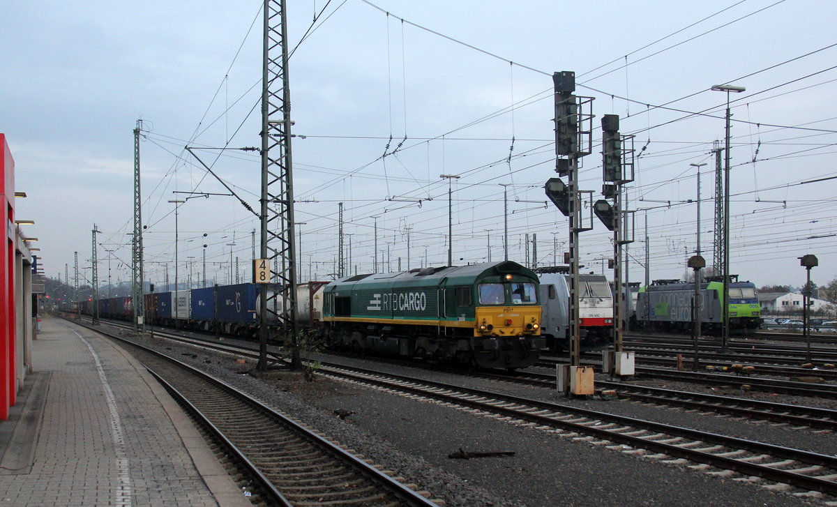 Die Class 66 PB17 von der Rurtalbahn-Cargo  fährt mit viel Dieselpower mit einem  langen KLV-Containerzug aus Frankfurt-Höchstadt am Main(D) nach Genk-Goederen(B) bei der Ausfahrt aus Aachen-West in Richtung Montzen/Belgien. 
Aufgenommen vom Bahnsteig in Aachen-West.
Bei Wolken am Kalten Nachmittag vom 21.11.2018.