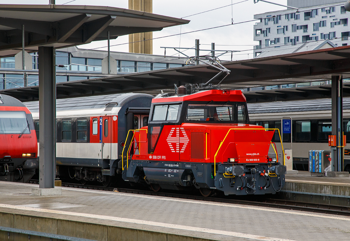 
Die Elektrische Zweifrequenz-Rangierlok Ee 922 022-9 (97 85 1 922 022-9 CH-SBB) der SBB zieht am 17.02.2017 einen IC-Wagenzug aus dem Bahnhof Basel SBB.

Die Schweizerische Bundesbahnen (SBB) bestellten im Dezember 2007 eine Serie von 21 Rangierlokomotiven Ee 922 bei Stadler. Die Ee 922 ist eine speziell für den Rangierdienst konzipierte elektrische Lokomotive, die auch im Streckenbetrieb eingesetzt werden kann. Sie basiert auf einer von der Stadler Winterthur AG entwickelten Fahrzeugfamilie für Traktionsbedürfnisse im Rangier- und Güterzugförderungsdienst.
Die Ee 922 zeichnet sich durch Kompaktheit, große Zugkraft und Leistung sowie optimale Sicht- und Arbeitsbedingungen für das Bedienpersonal aus.

Im Dezember 2013 bestellte die SBB vier weitere Ee 922, die 2015 von Stadler geliefert und in Genf und Zürich stationiert werden sollten. Die Ee 922 022-9 war die erste dieser Serie und wurde 2015 von Stadler gebaut.

Die Ee 922 verfügt über IGBT-Stromrichter und daher über zahlreiche Funktionen, welche eher von Regionaltriebzügen, als von Rangierfahrzeugen bekannt sind. Beispielsweise ist eine Rückspeisung für Bremsenergie in die Fahrleitung oder eine Vielfachsteuerung vorhanden. Auch die Höchstgeschwindigkeit von 100 km/h ist für eine Rangierlokomotive recht hoch - und übertrifft bei weitem die üblichen 45 bis 50 km/h der Ee 3/3. Die hohe  Höchstgeschwindigkeit befähigt die Ee 922, zusammen mit der Vielfachsteuerung, auch für kleinere Streckeneinsätze wie beispielsweise Überführungsfahrten. Die Lokomotive wurde vom Hersteller (Stadler)  für eine Höchstgeschwindigkeit von 120 km/h ausgelegt, um die Möglichkeit für einen Zweitauftrag offen zu halten. Konstruktiv ist die Lokomotive für ein Gesamtgewicht von 45 Tonnen ausgelegt. Ihr übliches Gewicht beträgt 44 Tonnen, kann aber auf 40 Tonnen herabgesetzt werden. Die Gewichtsdifferenz wird von zwei Ballastkörper mit je zwei Tonnen Gewicht erzeugt. Sie befinden sich seitlich an der Lokomotive und können mit einem Gabelstapler entfernt werden. Dies ist notwendig, da noch nicht alle Abstellgleise für 22,5 Tonnen Achslast (Streckenklasse D), sondern oft nur für 20 Tonnen Achslast (Streckenklasse  C) zugelassen sind.

Die äußeren Konturen entsprechen den Lichtraumprofilvorgaben nach UIC 505-1, und im Unterbereich den Vorgaben nach AB-EBV U3. Damit erfüllt die Lokomotive mit ihrer Bodenfreiheit vom 100 mm im Radbereich die Lichtraumprofil-Vorgaben für alle europäischen Hauptstrecken. Die Einstiegtüren ins Führerhaus befinden sich auf den Stirnseiten, um einen direkten Zugang zu den Rangiererbühnen zu ermöglichen, dafür sind die Vorbauten jeweils seitlich versetzt. Das klimatisierte Führerhaus ist für eine optimale Sicht großzügig verglast, die vorspringenden Vordächer schützen vor Sonneneinstrahlung sowie vor der Berührung spannungsführender Teile der Dachausrüstung.

Der elektrische Teil entspricht technisch weitgehend dem Stadler Flirt und dem neueren GTW. Er ist aber nicht baugleich, sondern musste aus Platzgründen an ein anderes Gehäuse angepasst werden. 

Die Ee 922 besitzt ein Schwingungstilgungssystem. Gerade ein zweiachsiges Eisenbahnfahrzeug mit geringem Achsstand neigt zu Schlingerbewegungen, da so gut wie keine Dämpfungen eingebaut werden können. 


Technische Daten:
Gebaute Stückzahl: 25
Spurweite: 1.435 mm (Normalspur)
Achsanordnung: Bo
Speisespannung: 15kV / 16.7Hz und 25kV / 50Hz
Anzahl Fahrmotoren: 2 
Länge über Puffer: 8.800 mm
Fahrzeugbreite: 3.100 mm
Fahrzeughöhe: 4.306 mm
Dienstgewicht: 40 t / 44 t (umrüstbar, je nach Streckenklasse)
Achsabstand: 4.000 mm
Max Leistung am Rad: 750 kW (1.020 PS)
Dauerleistung:  600 kW
Anfahrzugkraft: 120 kN
Höchstgeschwindigkeit: 40 km/h im Rangiergang; 100 km/h (Auslegung 120 km/h)
Treibraddurchmesser:  1.100 mm (neu)
Stromsystem:  15 kV 16,7 Hz und 25 kV 50 Hz
Lokbremse:  Druckluftbremse, Federspeicher, elektrische Bremse
Zugbremse:  automatische Druckluftbremse
Zugheizung:  ZZS 1000 V 800 A