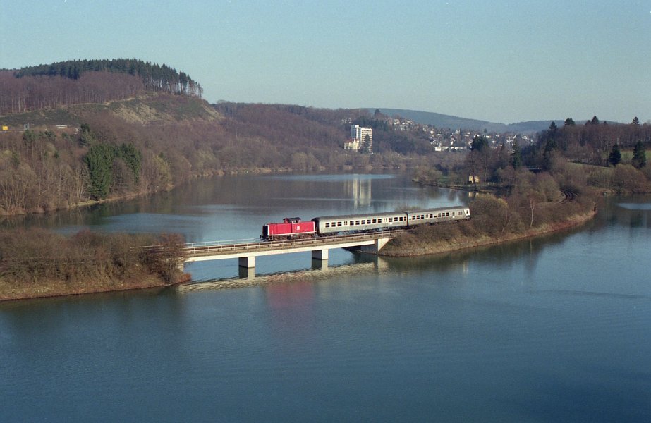 Die erste orientrote 212 des Bw Hagen war die 212 298, die am 16.03.1990 ihren N 6735 von Olpe nach Finnentrop über den Olper Biggedamm zieht