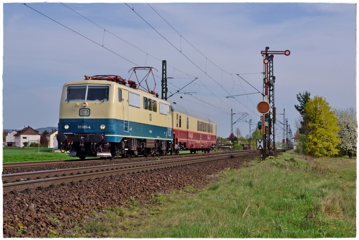 Die frisch in ozenanblau/beige lackierte 111 001-4 fotgrafiert mit einem  Rheingold -Clubwagen am nördlichen Einfahrtssingal in Hirschaid am 7. April 2014.