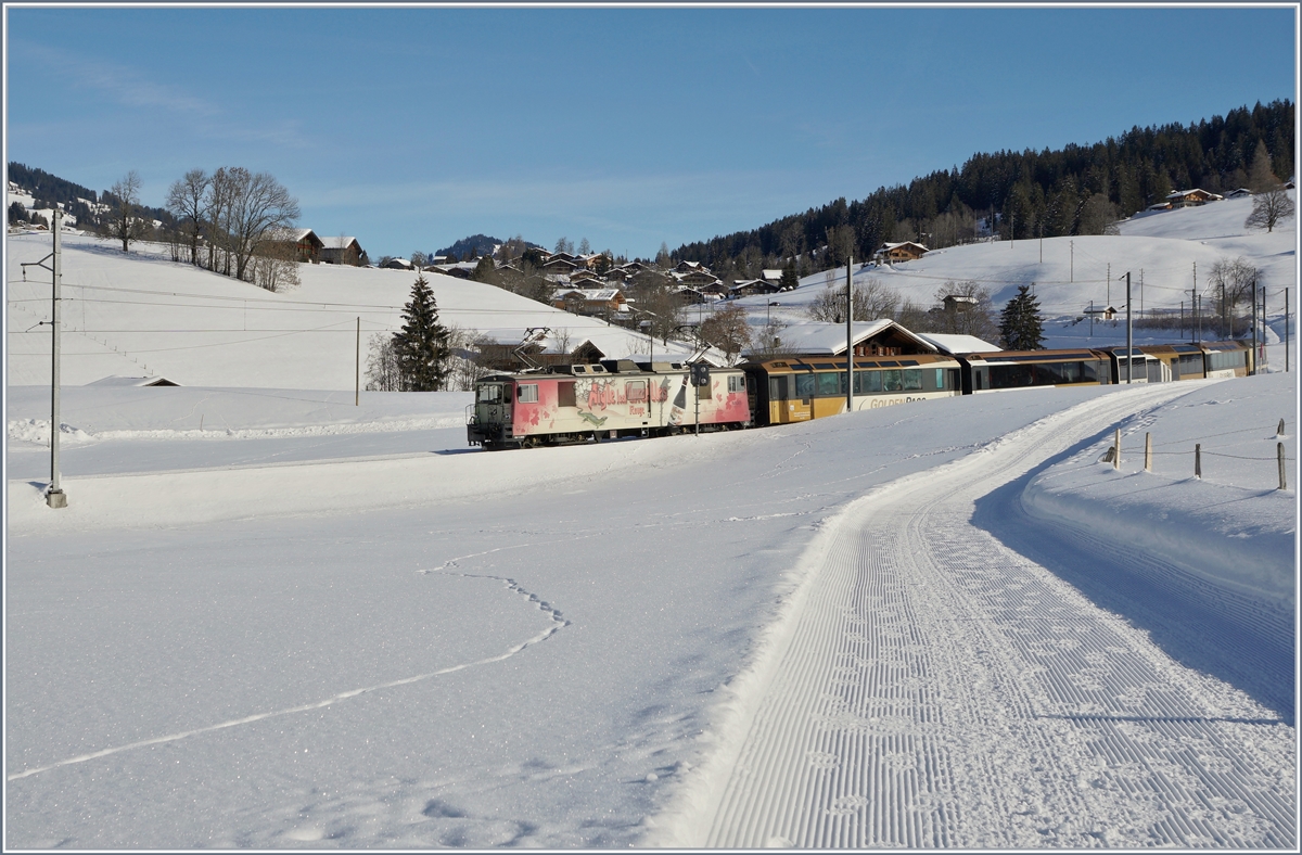 Die GDe 4/4 N° 6006  Aigle les Murailles  ist mit ihrem IR 2115  GoldenPass MOB Panoramic  zwischen Schönried und Gruben auf dem Weg von Zweisimmen nach Montreux. 

6. Feb. 2019