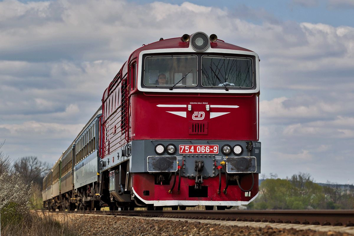 Die kirschrote 754 066-9 dieselt mit einem Os in Osvracin vorüber.Bild vom 20.4.2017